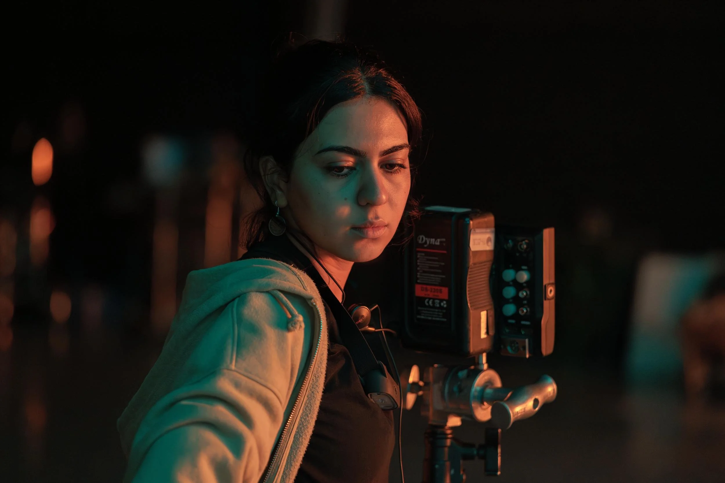 Ahlan Simsim unit still: a crew member looks at a camera monitor on a dark studio set.