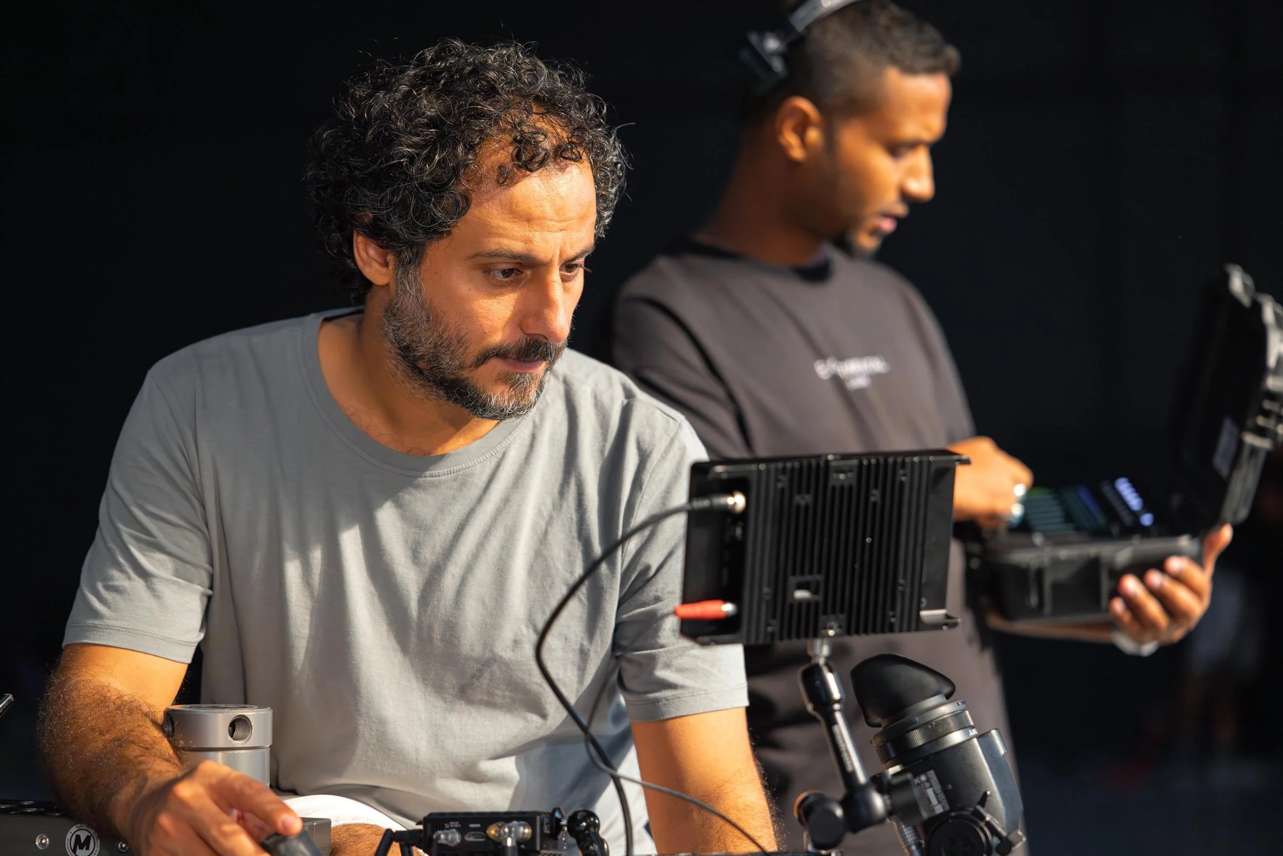Ahlan Simsim unit still: Two crew members work with monitors and technical equipment on set.