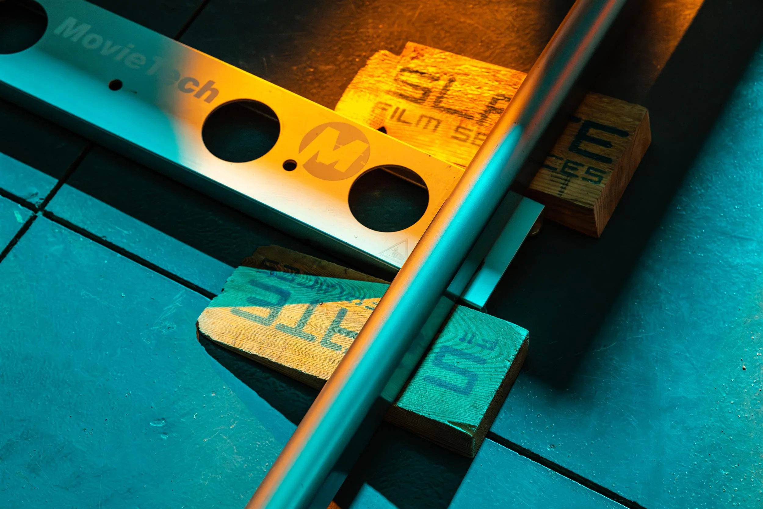 Ahlan Simsim unit still: close-up of a MovieTech dolly track and wooden shims on a studio floor.