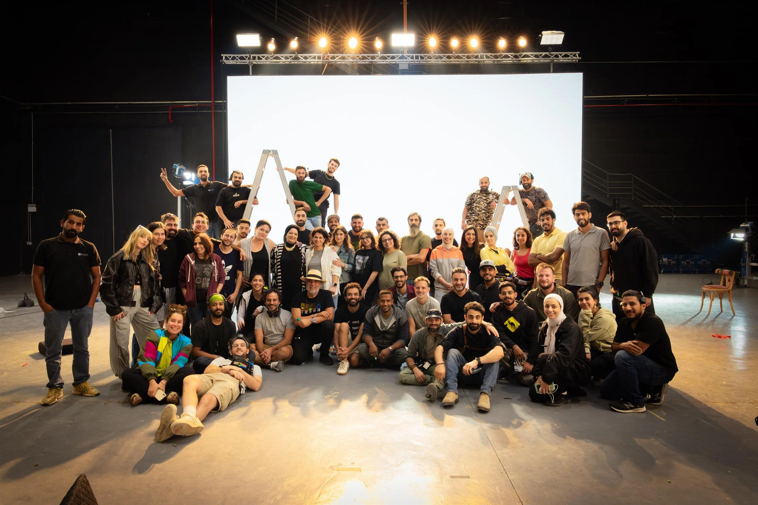 Ahlan Simsim unit still: a large group of production crew members pose together in a studio.