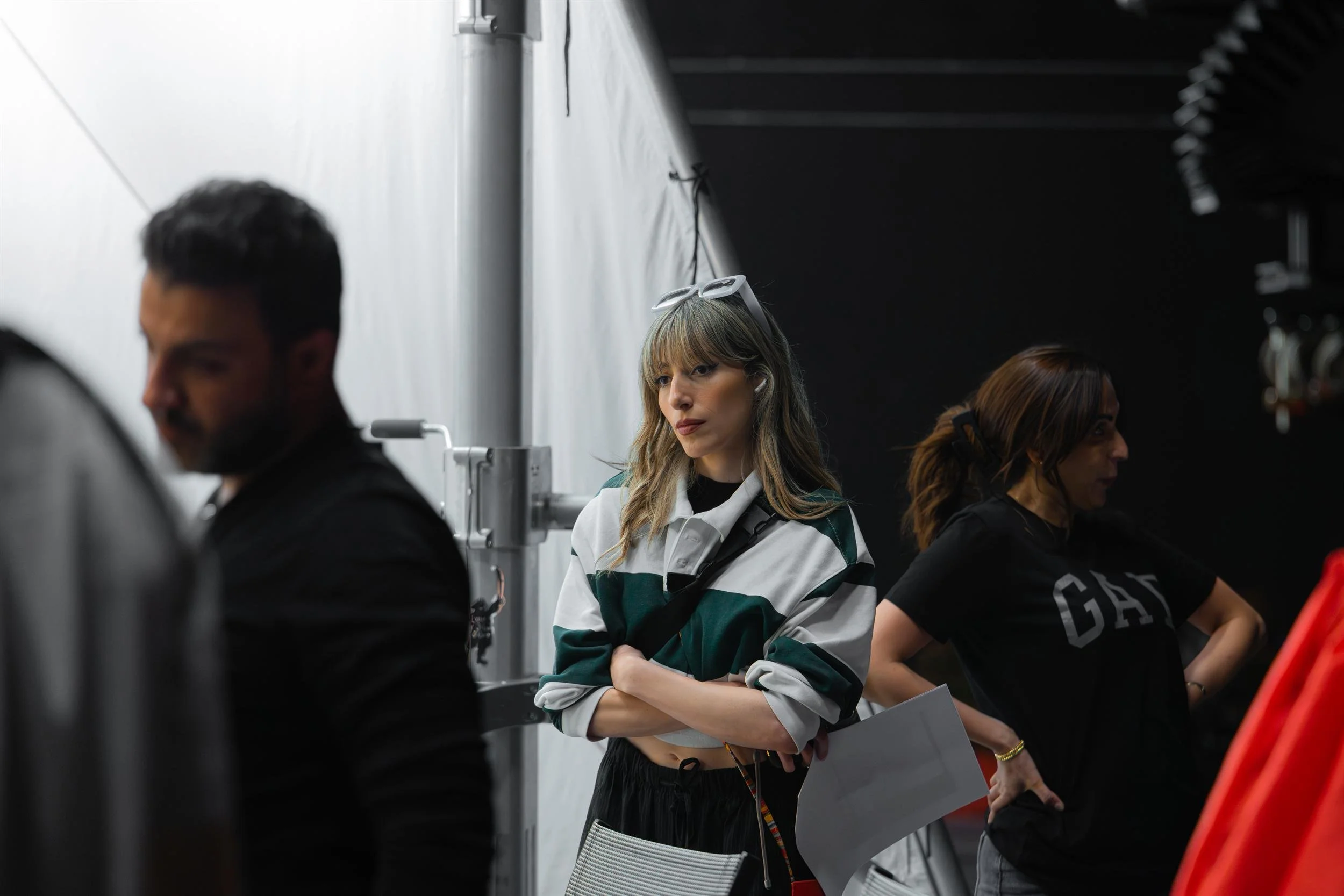 Ahlan Simsim unit still: A crew member with sunglasses on her head stands with arms crossed between colleagues on set.
