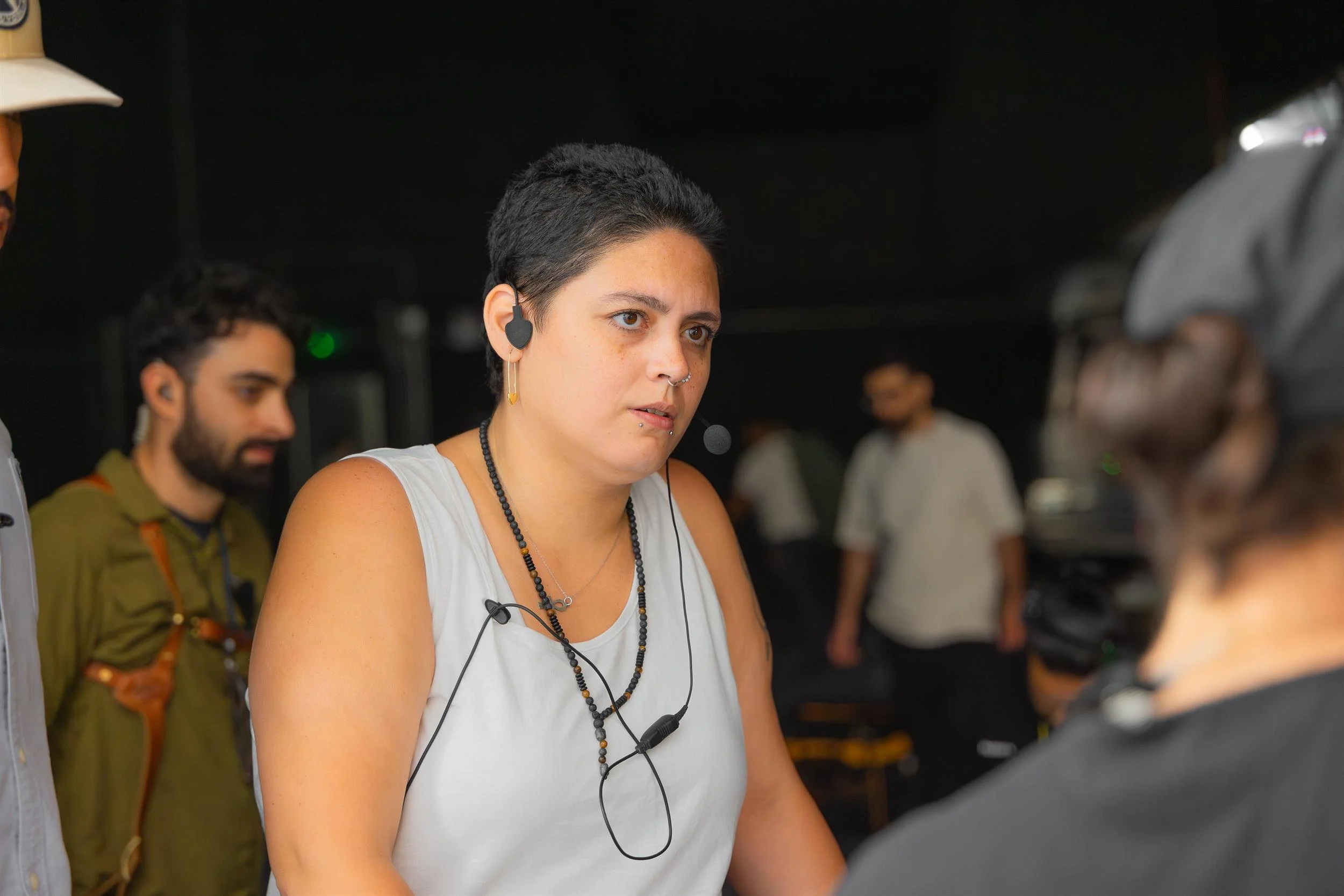 Ahlan Simsim unit still: A crew member wearing a headset works on a dark studio set among colleagues.