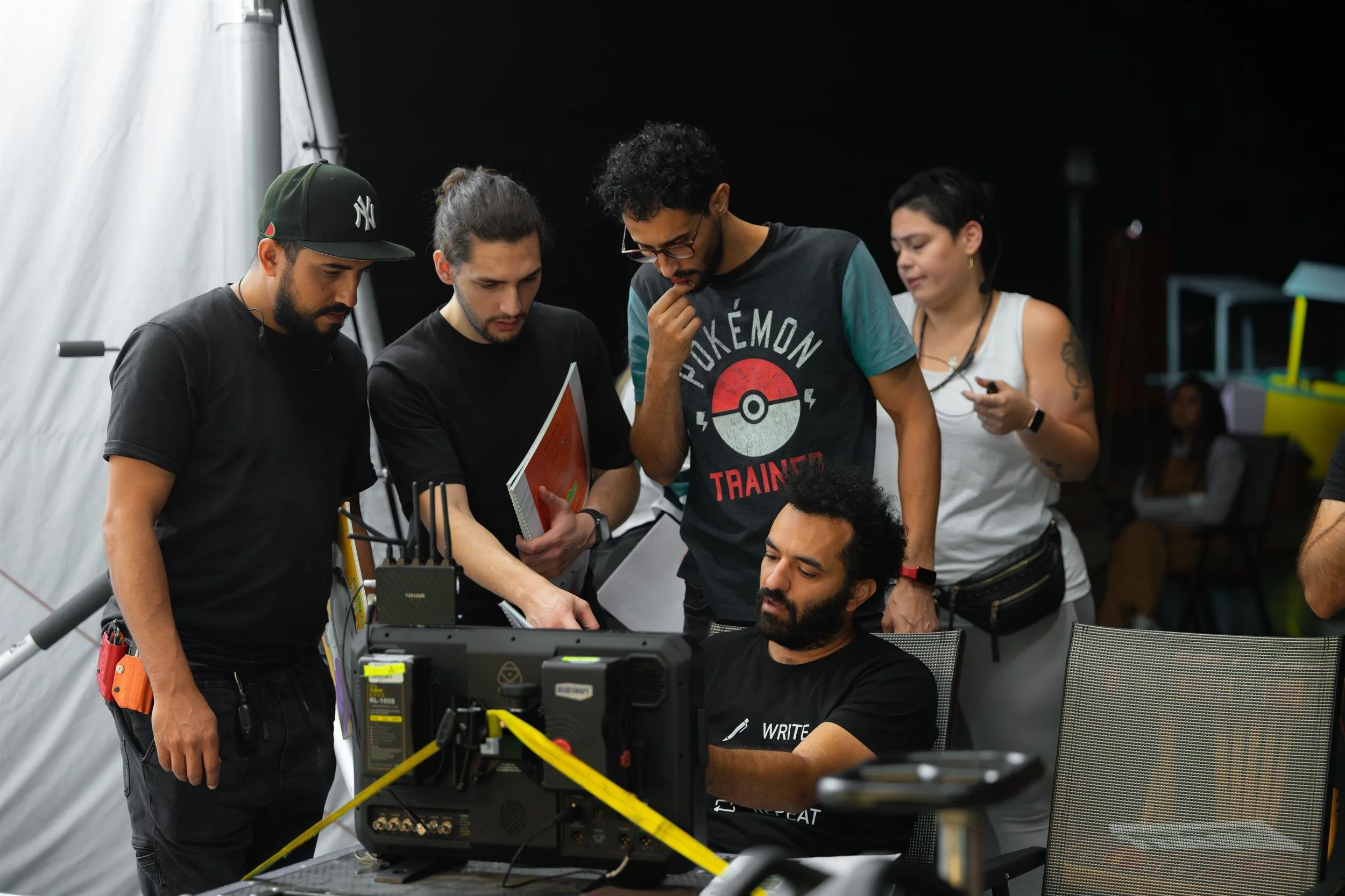 Ahlan Simsim unit still: A group of crew members gathers around a production monitor on set to review footage.
