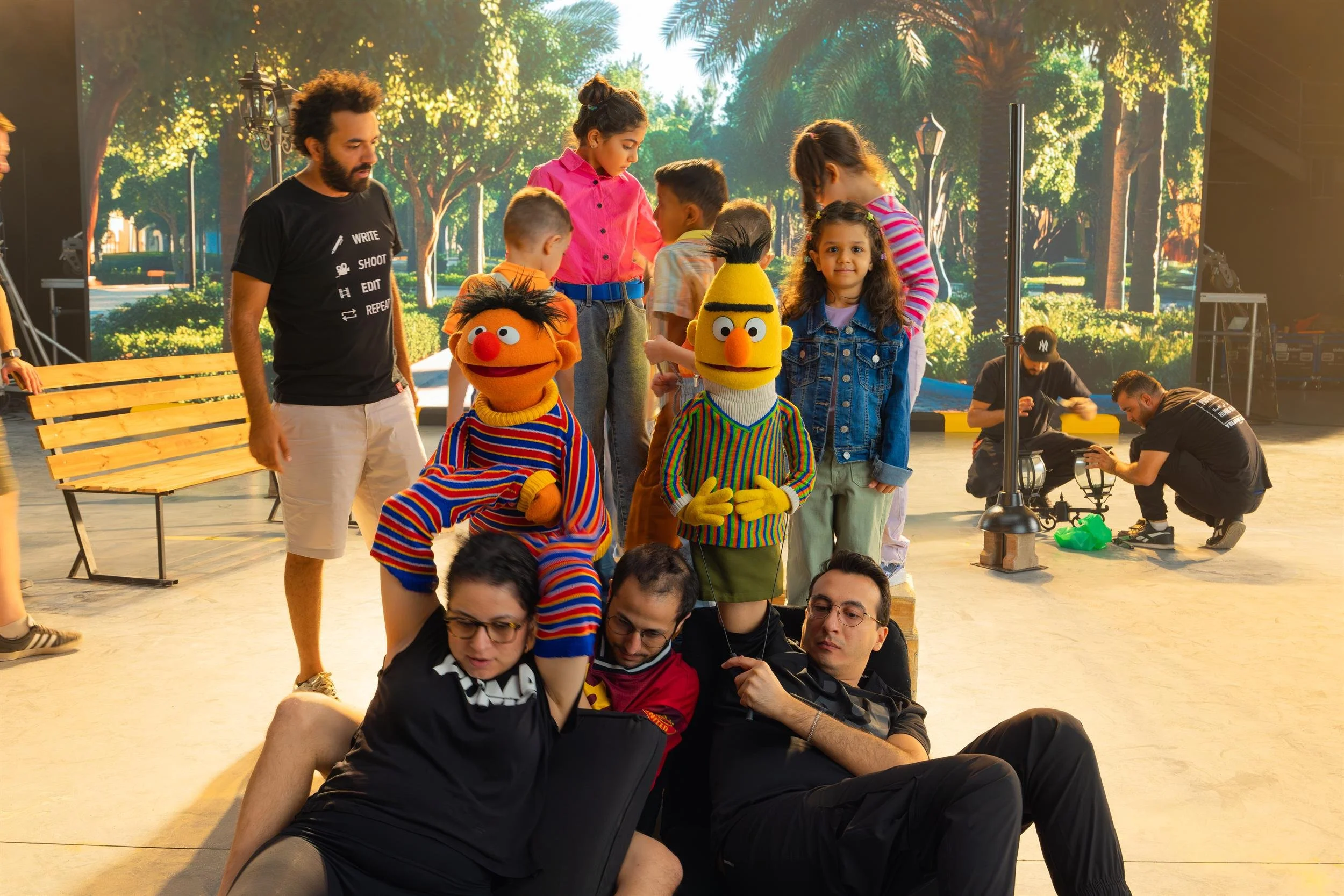 Ahlan Simsim unit still: Puppeteers operate Ernie and Bert on the studio floor while children and crew look on.