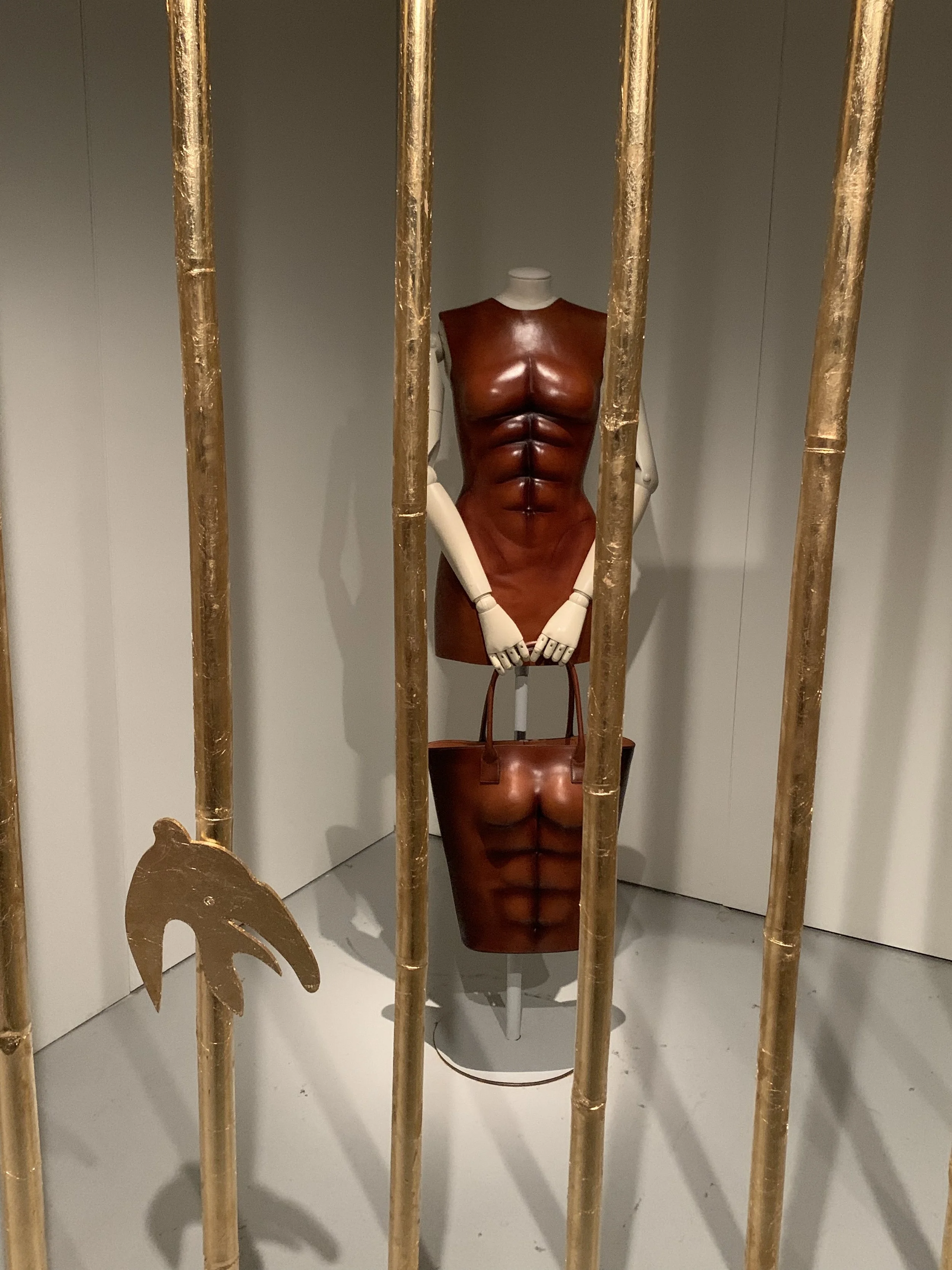 Images of Sciaparelli brown leather muscle carved bodice and bag at the Musée des Arts Décoratifs Paris