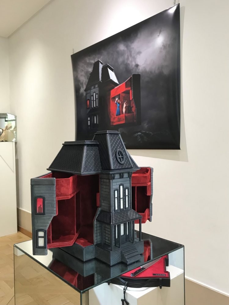An image of a black leather bag with red interior  in the shape of the Psycho house from Hitchcock. at the Joyce gallery in paris