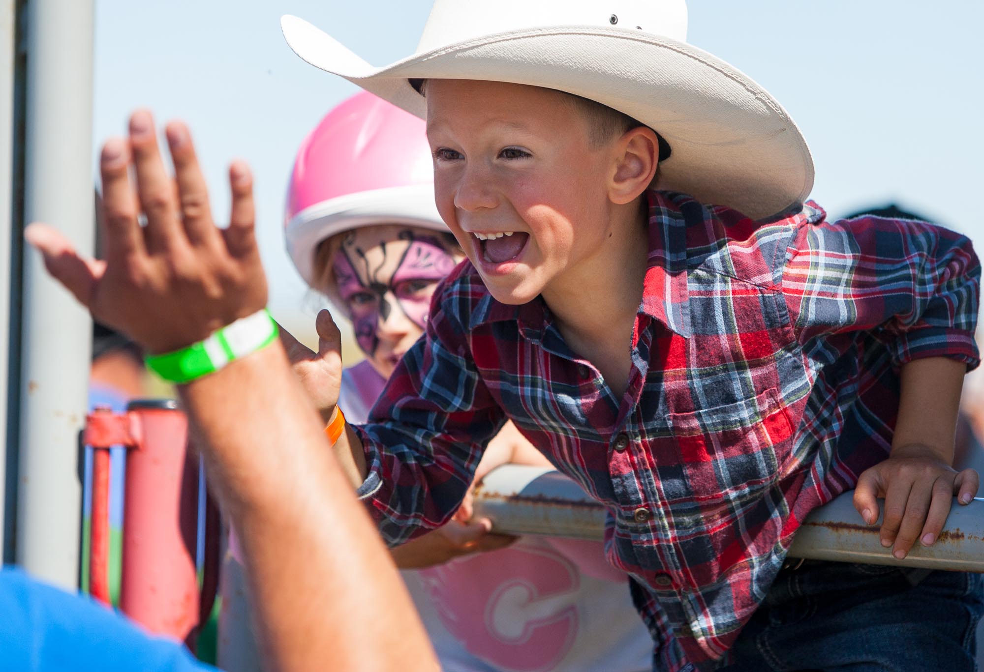 A young fan high-fives participants of the Mayor's Calf Scramble Challenge as they leave the arena during an intermission in the Didsbury Fair and Rodeo at the Didsbury Rodeo grounds north of Didsbury, Alta. on Aug. 20, 2011.