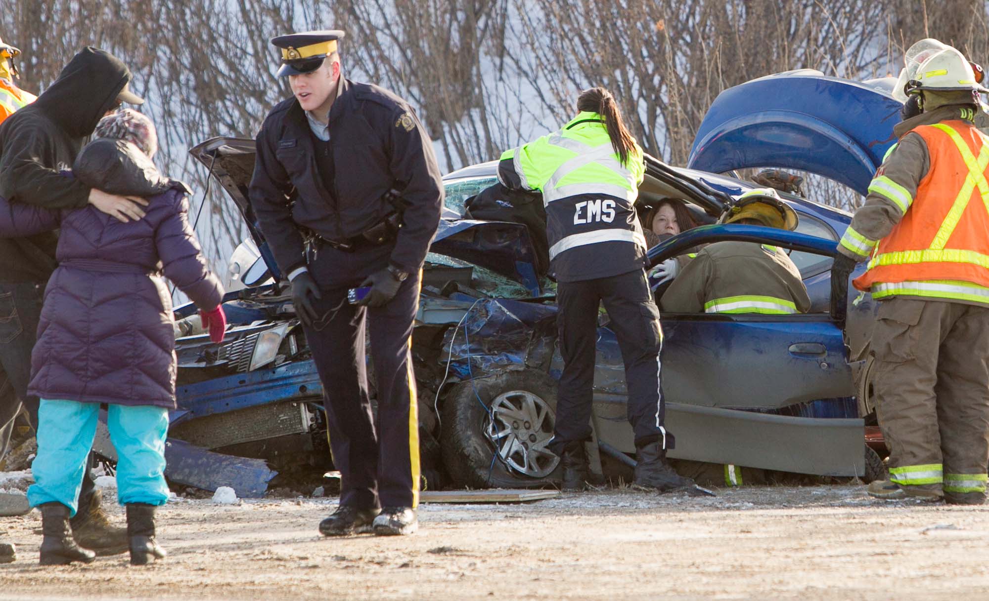 Firefighters and EMS workers tend to a victim of a motor vehicle collision at the intersection of Highway 587 and the northbound off-ramp of Highway 2 near Bowden, Alta. on Jan. 8, 2013.