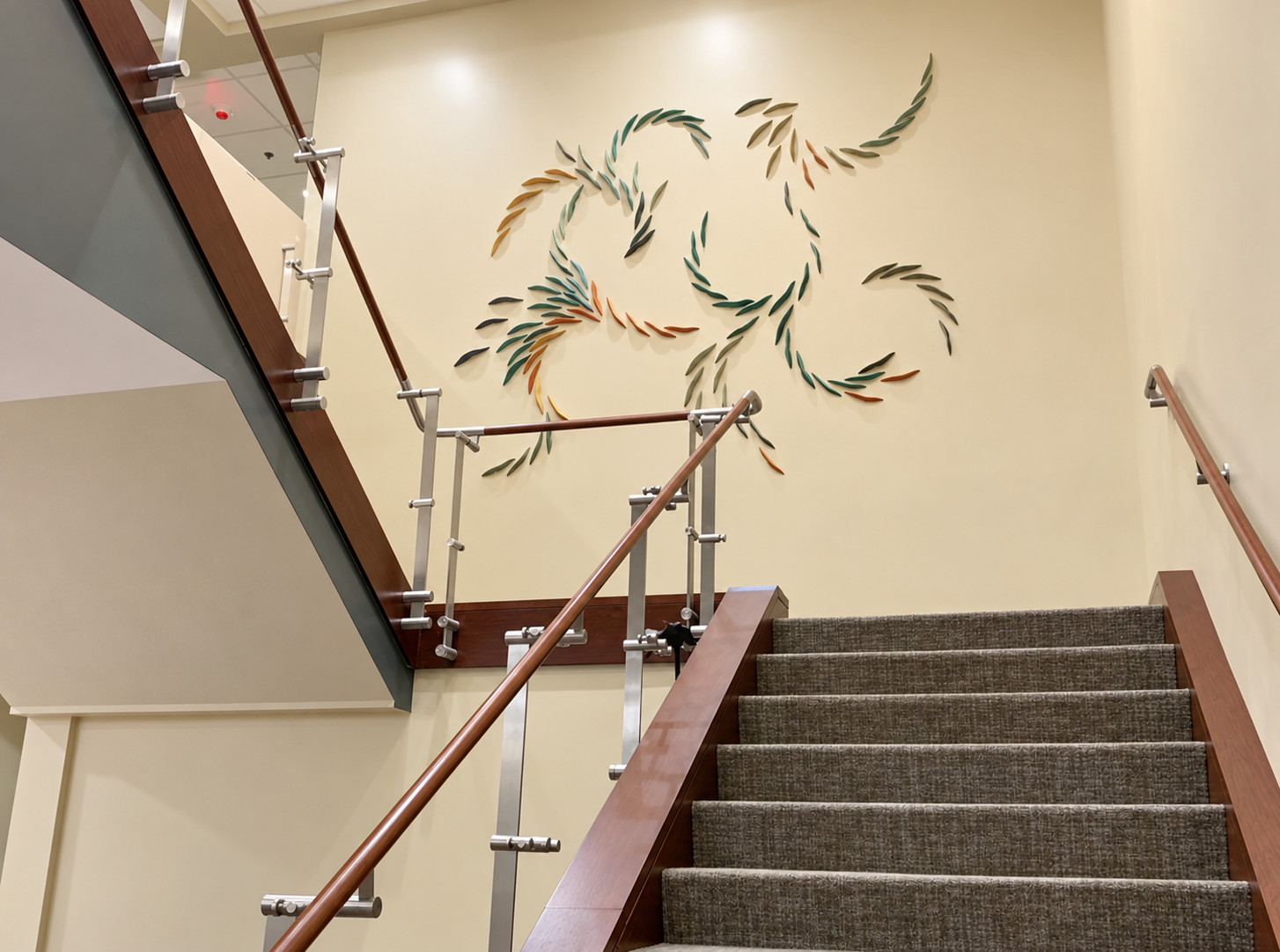 Warm stairwell with ceramic leaf artwork.png