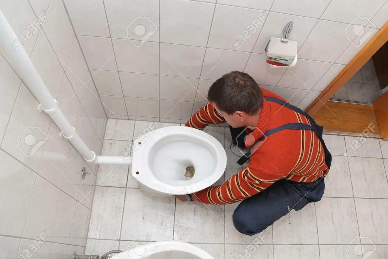 15832532-Plumber-replacing-broken-toilet-in-a-washroom-Stock-Photo-repair.jpg