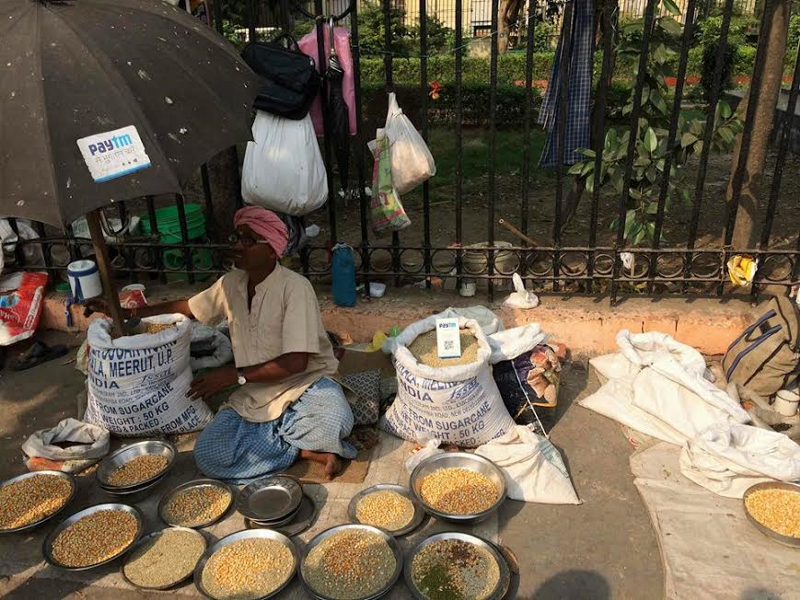 Vendedor ambulante de especias en la India, cobrando a través de PayTM