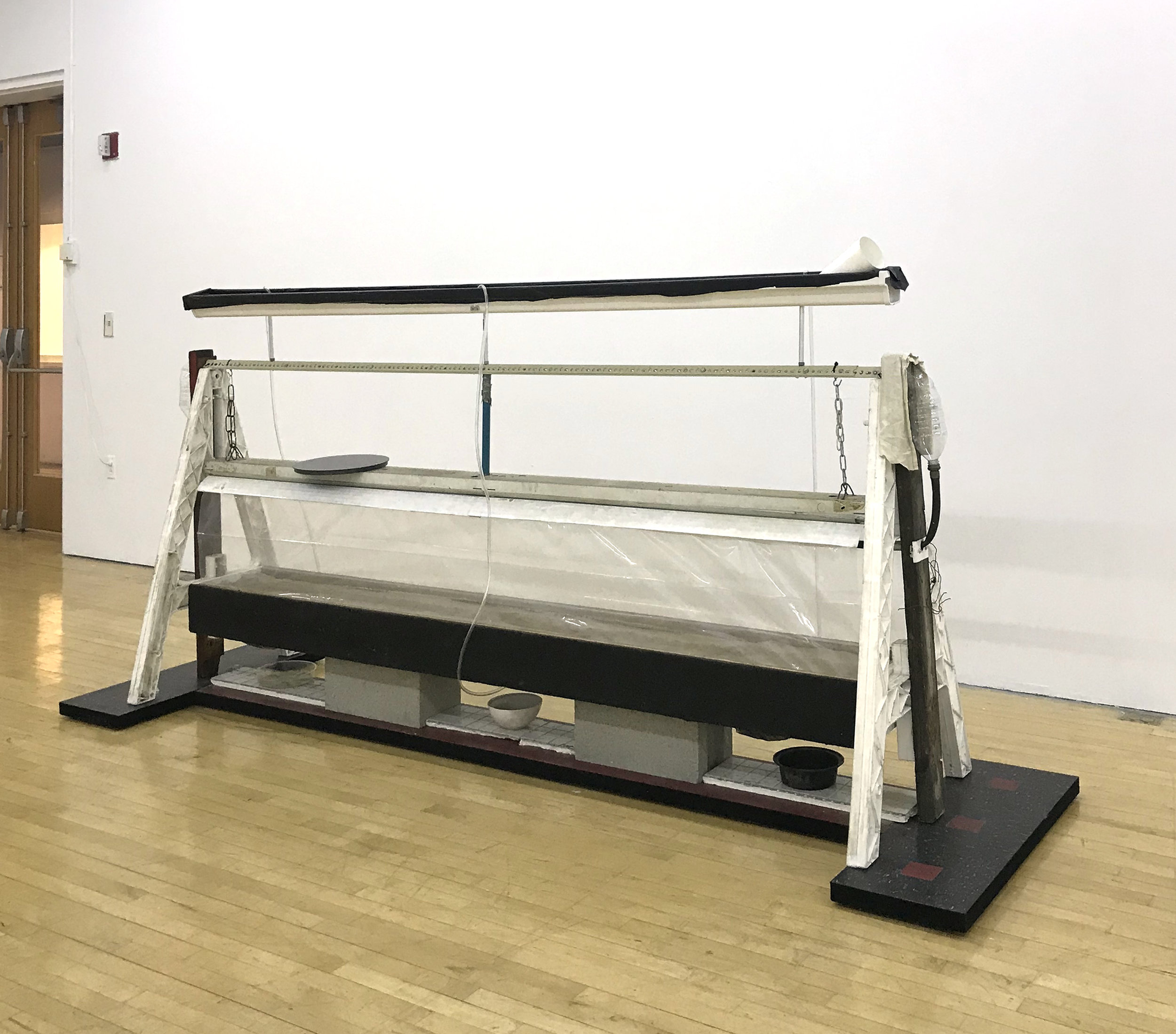  Jonathan Mildenberg  A Song of Ascents , 2018 wood, steel, rubber floor tile, Plasticade barricade A-frames, commercial steel shelving brackets, PVC vinyl tubing, gravel, sand, plastic tarp, Velcro, Florescent lighting fixture, chain, zip ties, alum