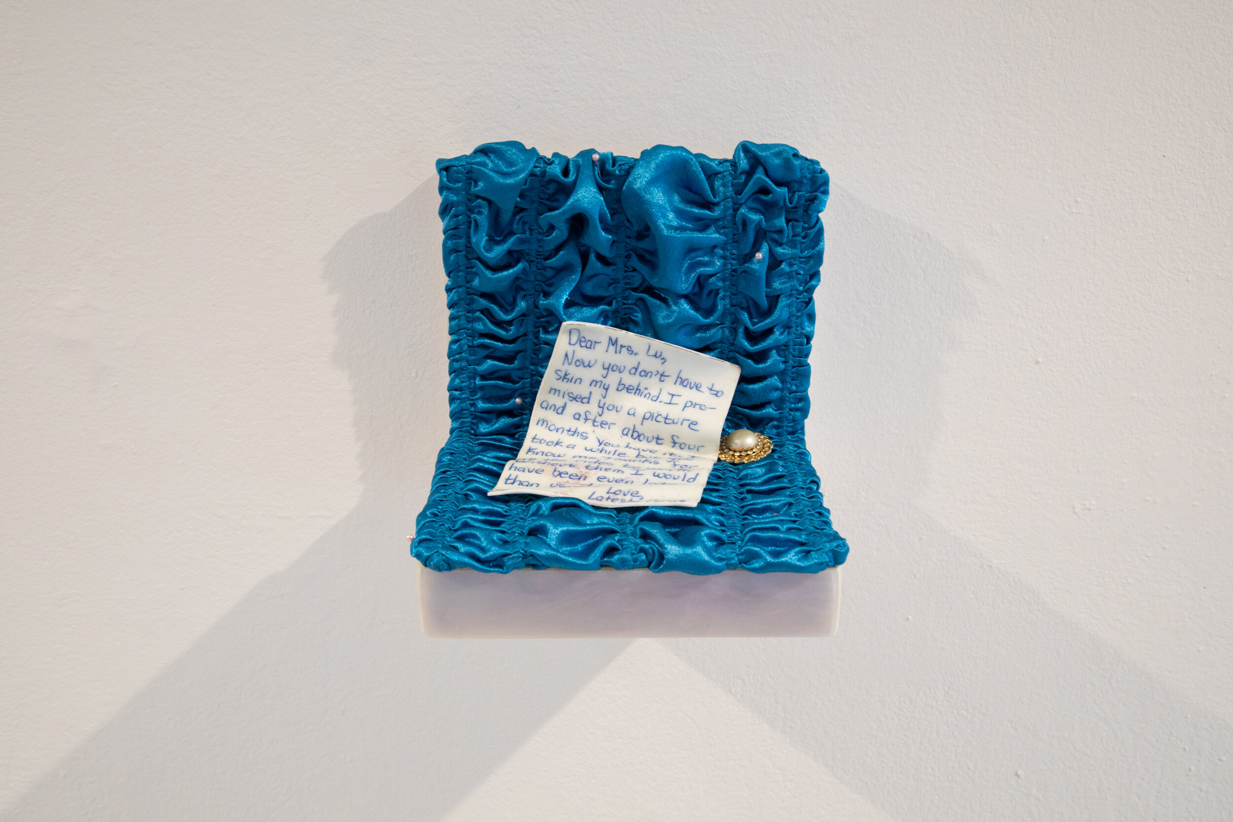  Karinne Smith  Pinkie , 2020 (letter detail) Blue Satin, Vanilla Fondant, Earring, Pink Sewing Pins, Pearlescent Acrylic, Wood 8 x 7 x 7 inches (20 x 18 x 18 cm) 