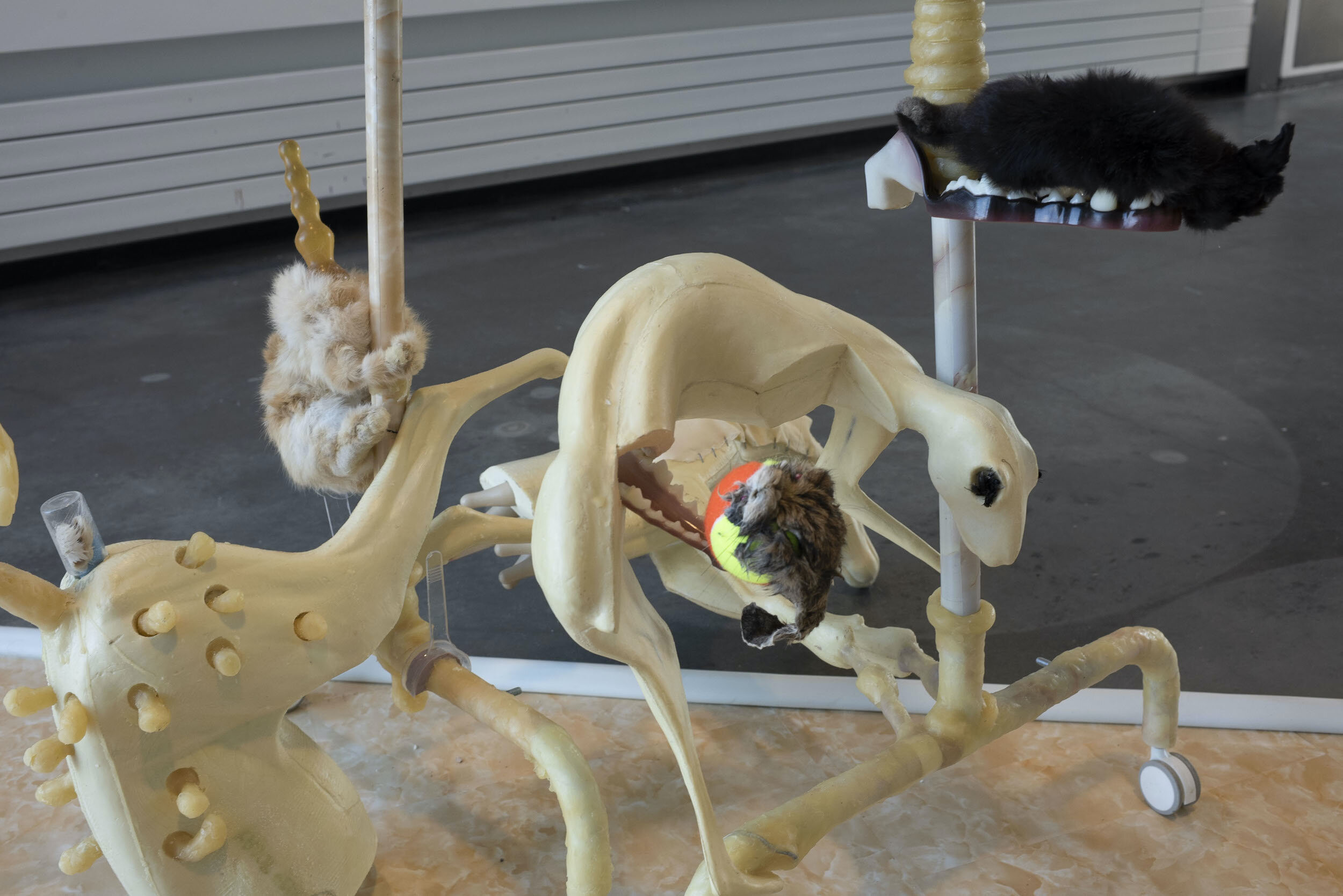  Lauren Lee  Mother: (Cooking Steaks for Thick-Necked Boys) , 2019 Taxidermy forms, beef trachea, rabbit hide, latex cast of my armpit and breast, wax, plastic fingers for manicure practice, IKEA clothing rack, yellow jade decals, breast stress ball,