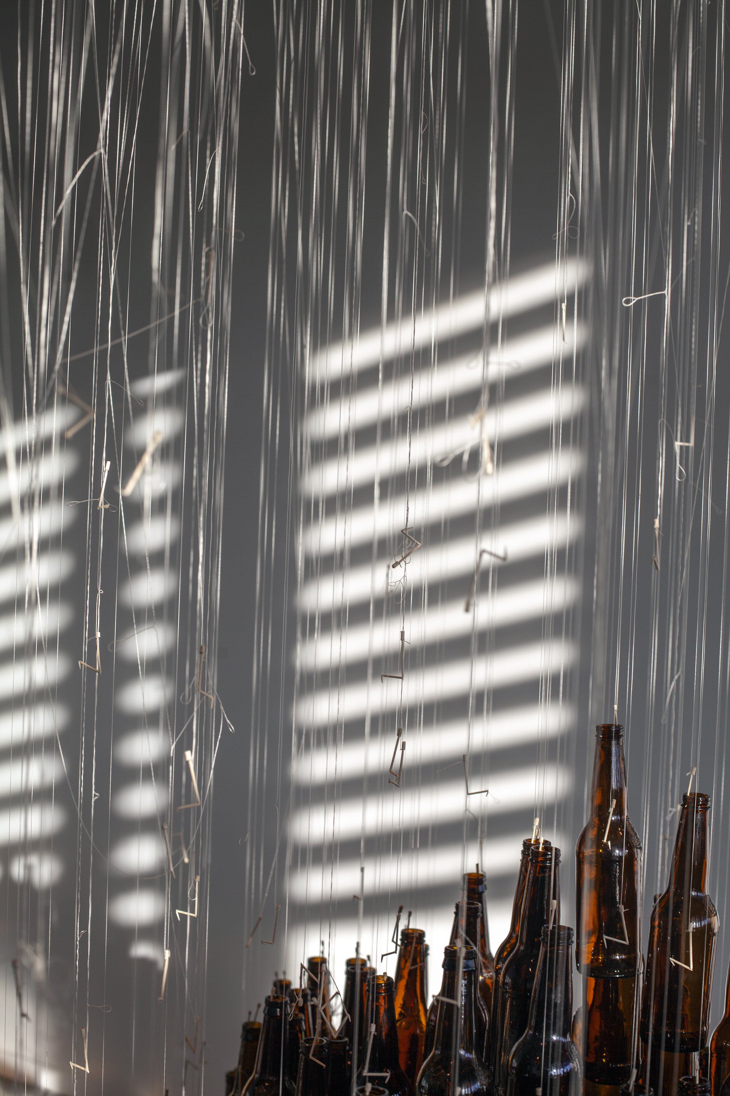  Anna Miller  HOURGLASS , 2019  Toothpicks, beer bottles, thread, wood, rope 180 x 108 inches (457 x 274 cm) 