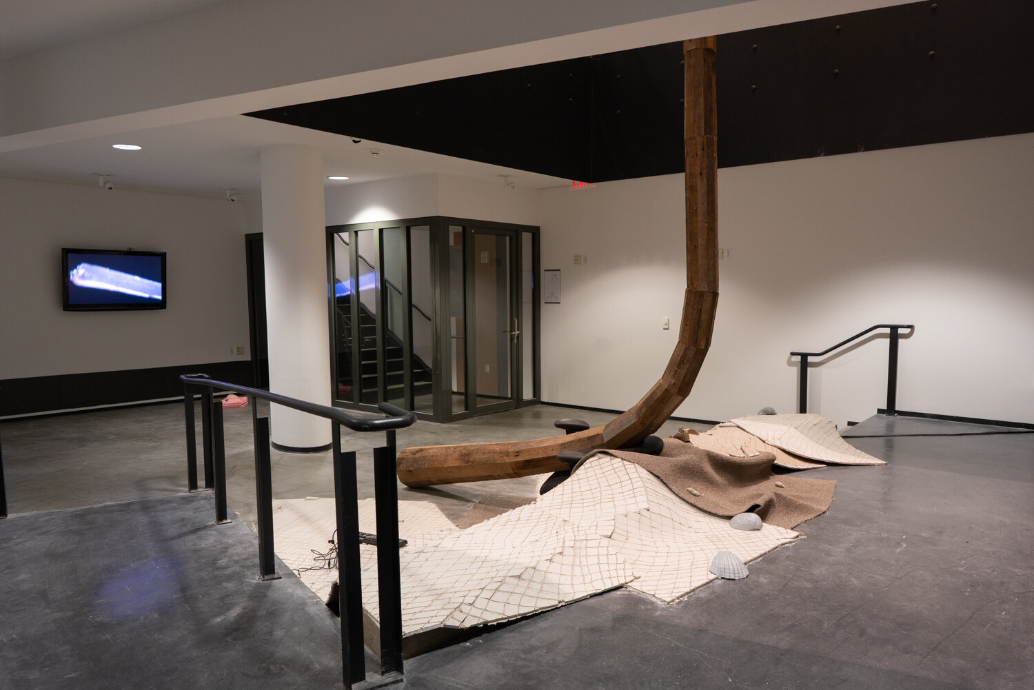  Alex Zak  Swamped , 2019 (lower level view) Sheet rock, plaster wrap, carpet, wood, steel, aluminum, paint, cement, sand, oven-bake clay,   office chair, modified ceiling fan, Monitor, Keyboard, aquarium volcano, red sharpie 192 x 204 x 196 inches (