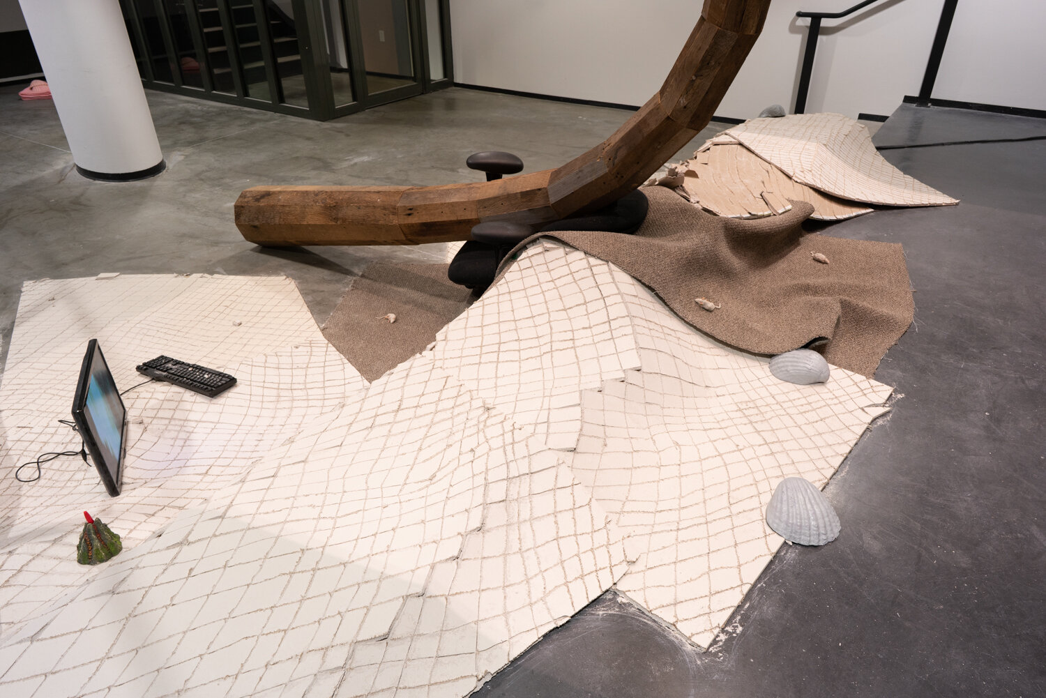  Alex Zak  Swamped , 2019 (detail) Sheet rock, plaster wrap, carpet, wood, steel, aluminum, paint, cement, sand, oven-bake clay,   office chair, modified ceiling fan, Monitor, Keyboard, aquarium volcano, red sharpie 192 x 204 x 196 inches (488 x 305 