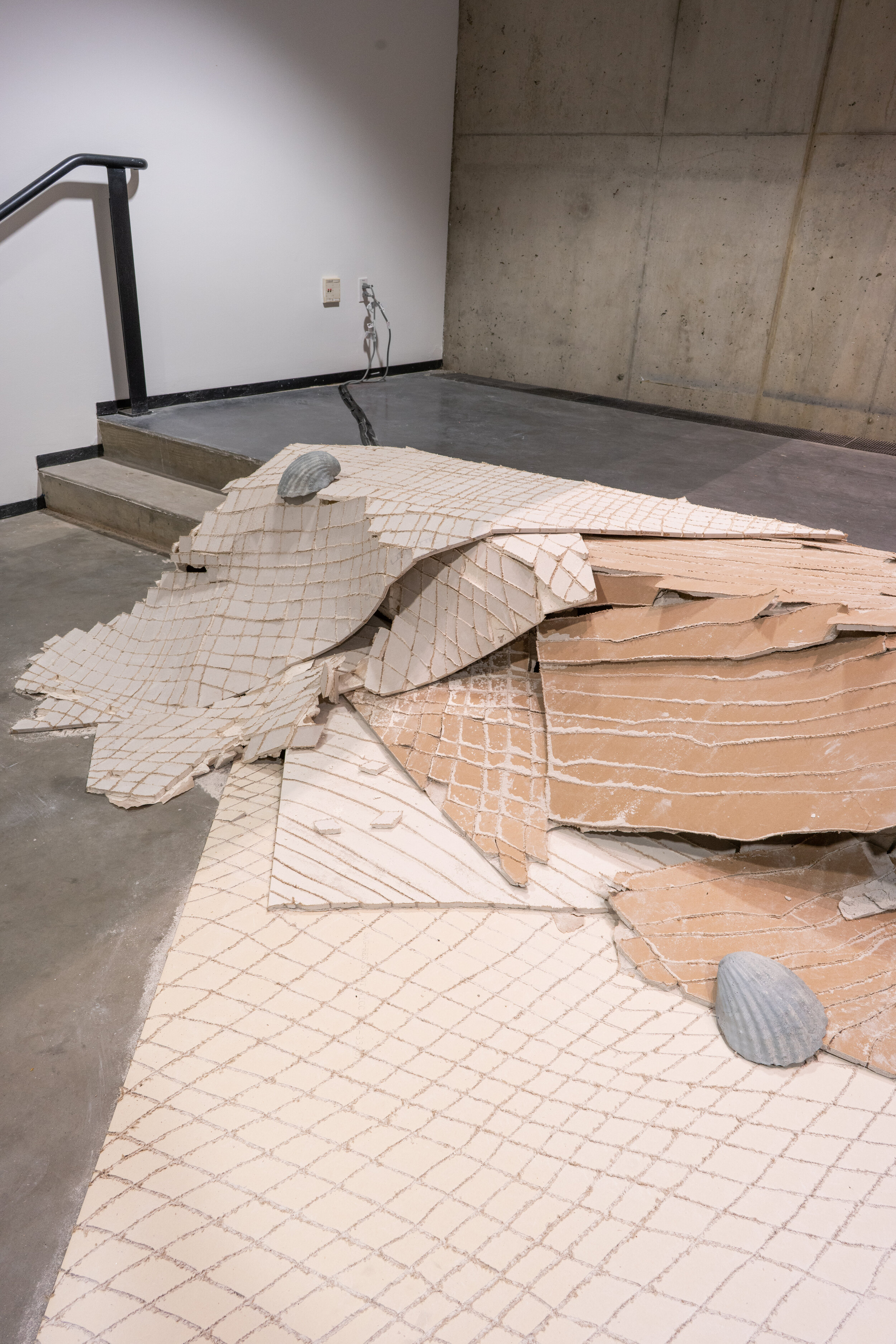  Alex Zak  Swamped , 2019  Sheet rock, plaster wrap, carpet, wood, steel, aluminum, paint, cement, sand, oven-bake clay,   office chair, modified ceiling fan, Monitor, Keyboard, aquarium volcano, red sharpie 192 x 204 x 196 inches (488 x 305 x 498 cm