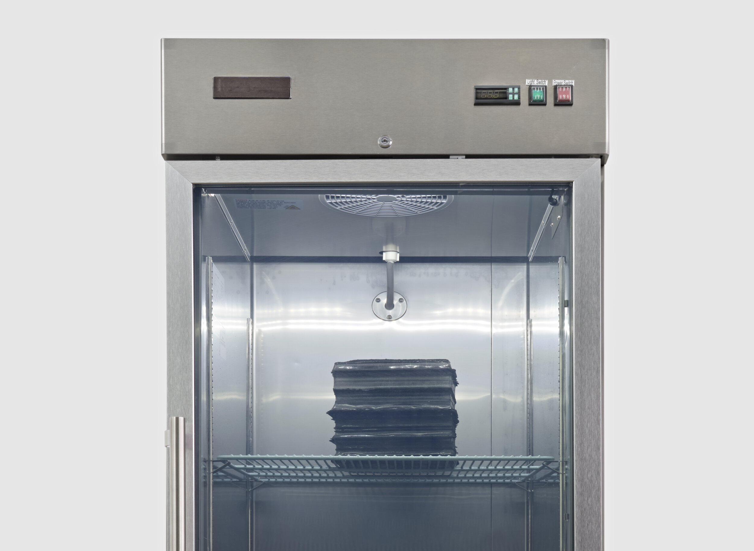  Sae Jun Kim  Solicitude in stratum’s loss , 2021 commercial freezer, water, carbon sediment  82 x 29 x 34 inches (208 x 74 x 86 cm) 