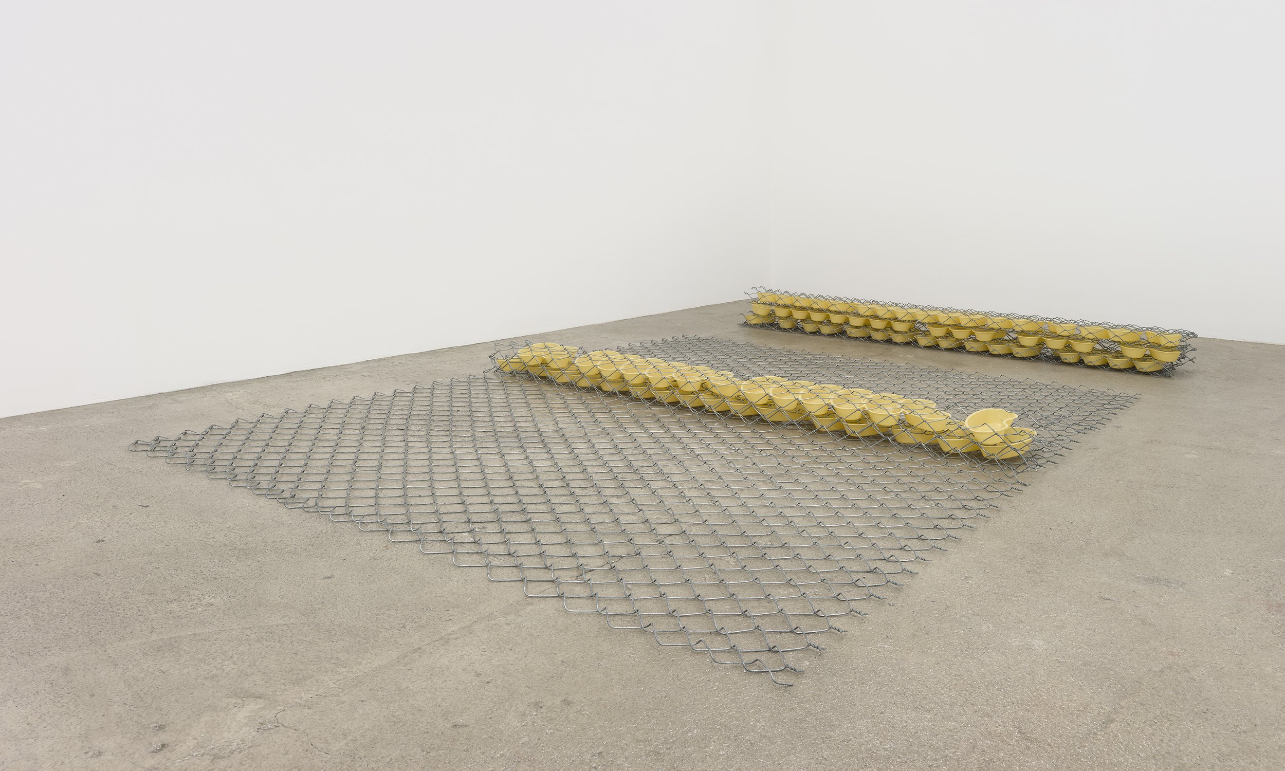 Bat-Ami Rivlin Untitled (fence, bedpans) , 2021 chain link fencing, yellow kidney basins 8 x 120 x 72 inches (20 x 305 x 183 cm) (BR21)