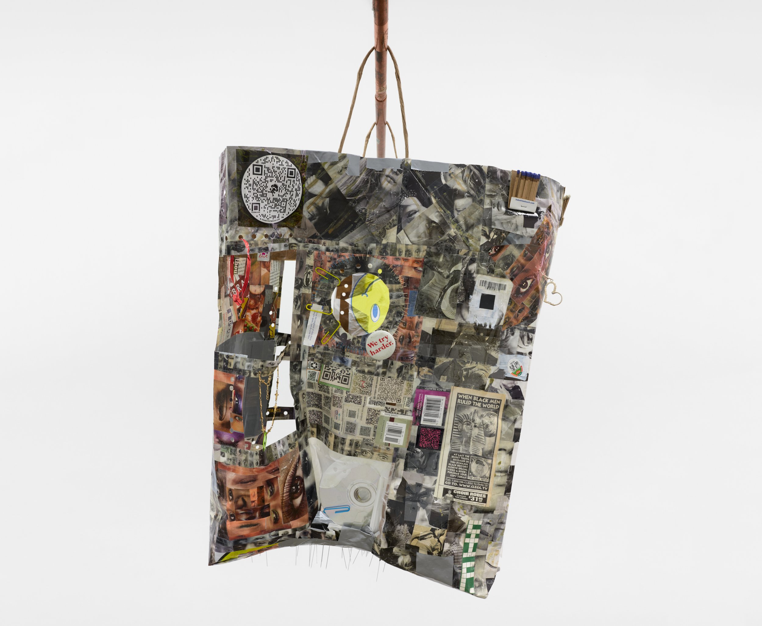  Elzie Williams III  If I Ruled The World (Time Traveler Bag) , 2023 (side 1) magazines, found qr codes, clear tape, found objects, copper  26 x 18 x 6 inches (66 x 46 x 15 cm) EW9 