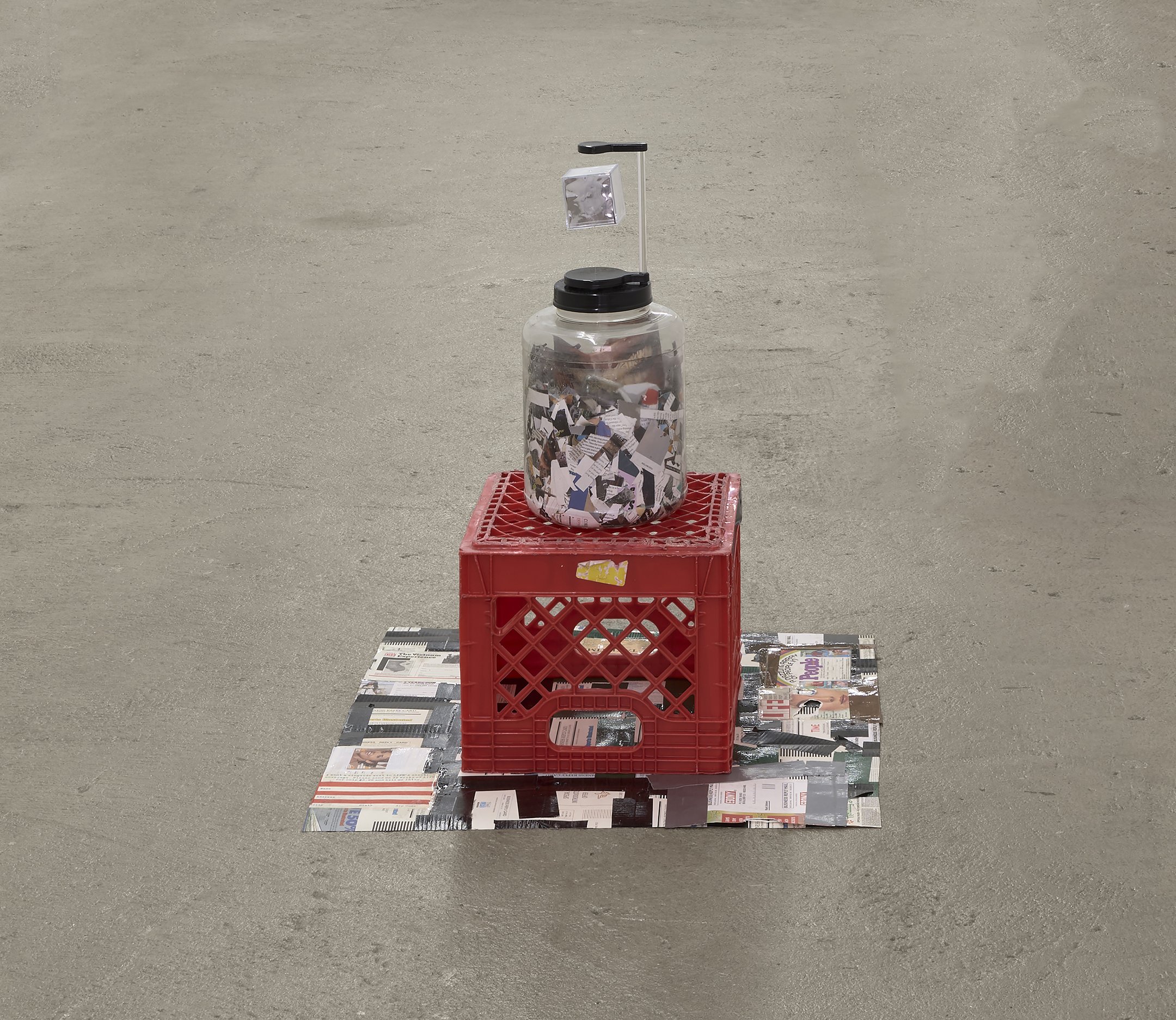  Elzie Williams III  The News , 2023 plastic milk carton, Utz Cheeseballs jar, levitating display, mylar, plexiglass cube, duct tape,  magazine subscription postcards, terrarium with ferns and soil, shredded magazines 29 x 26 x 26.5 inches (74 x 66 x