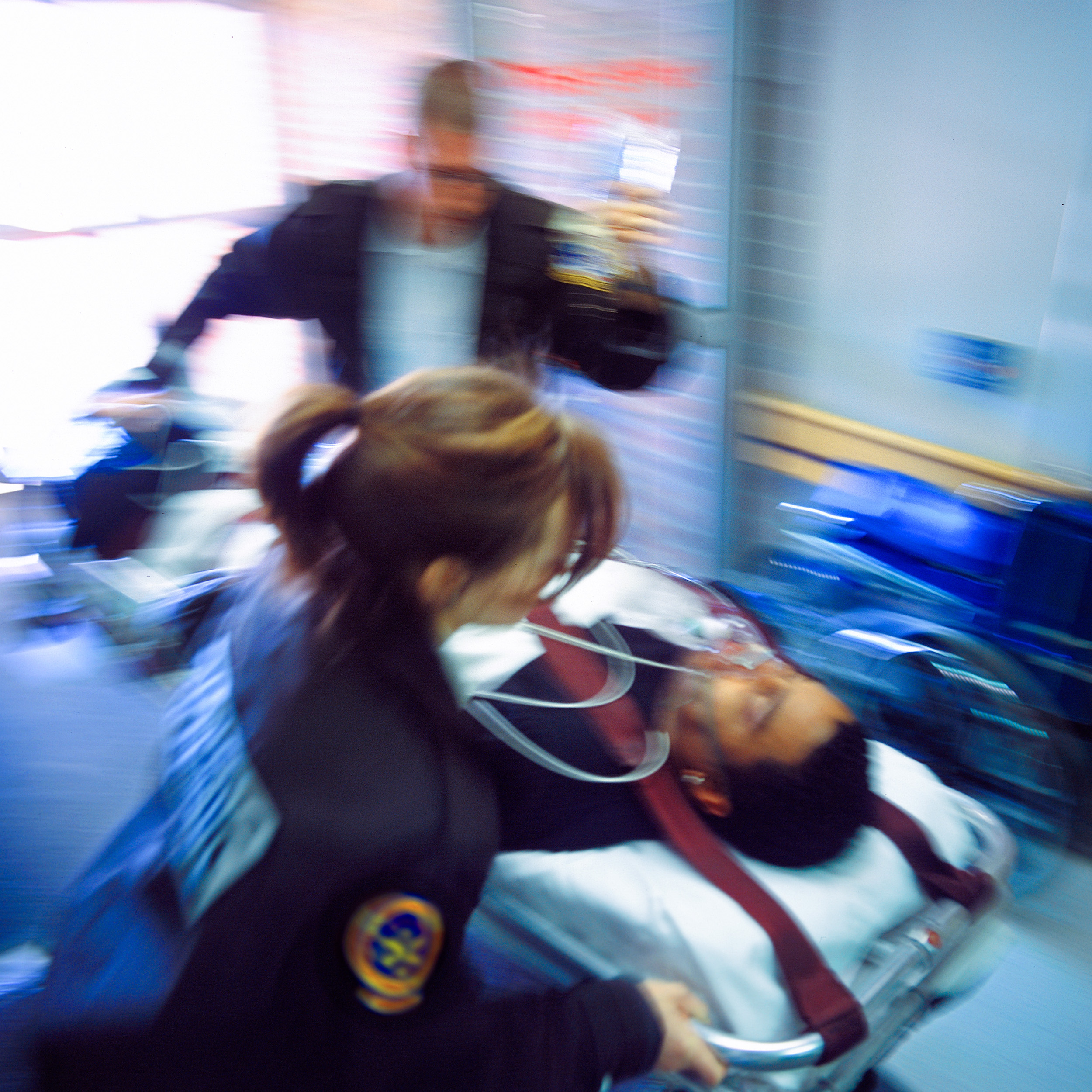 Paramedics rushing a patient in to an emergency department.