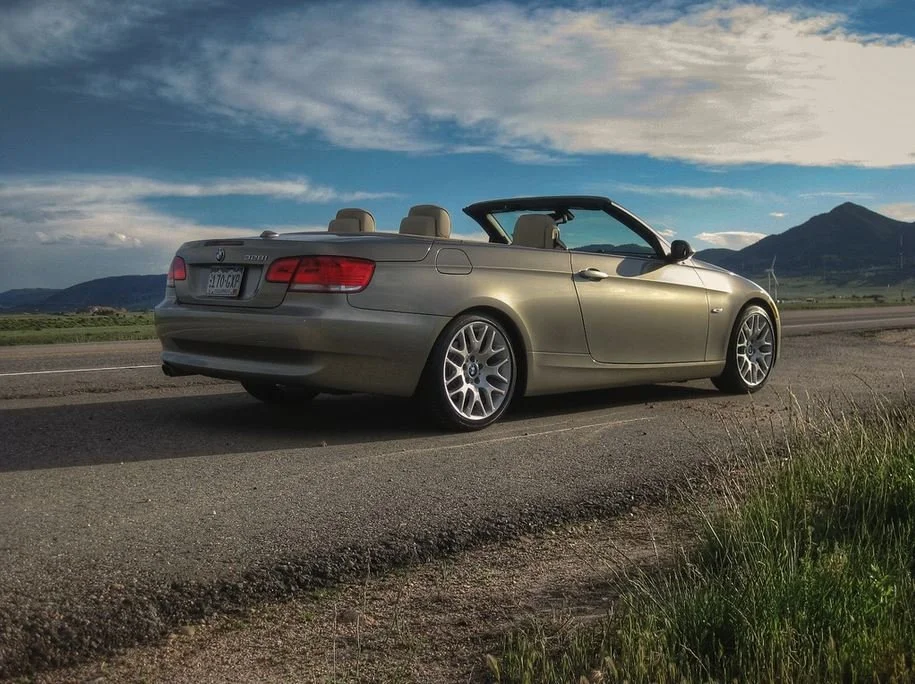 BMW convertible on a Colorado road with mountains in the background