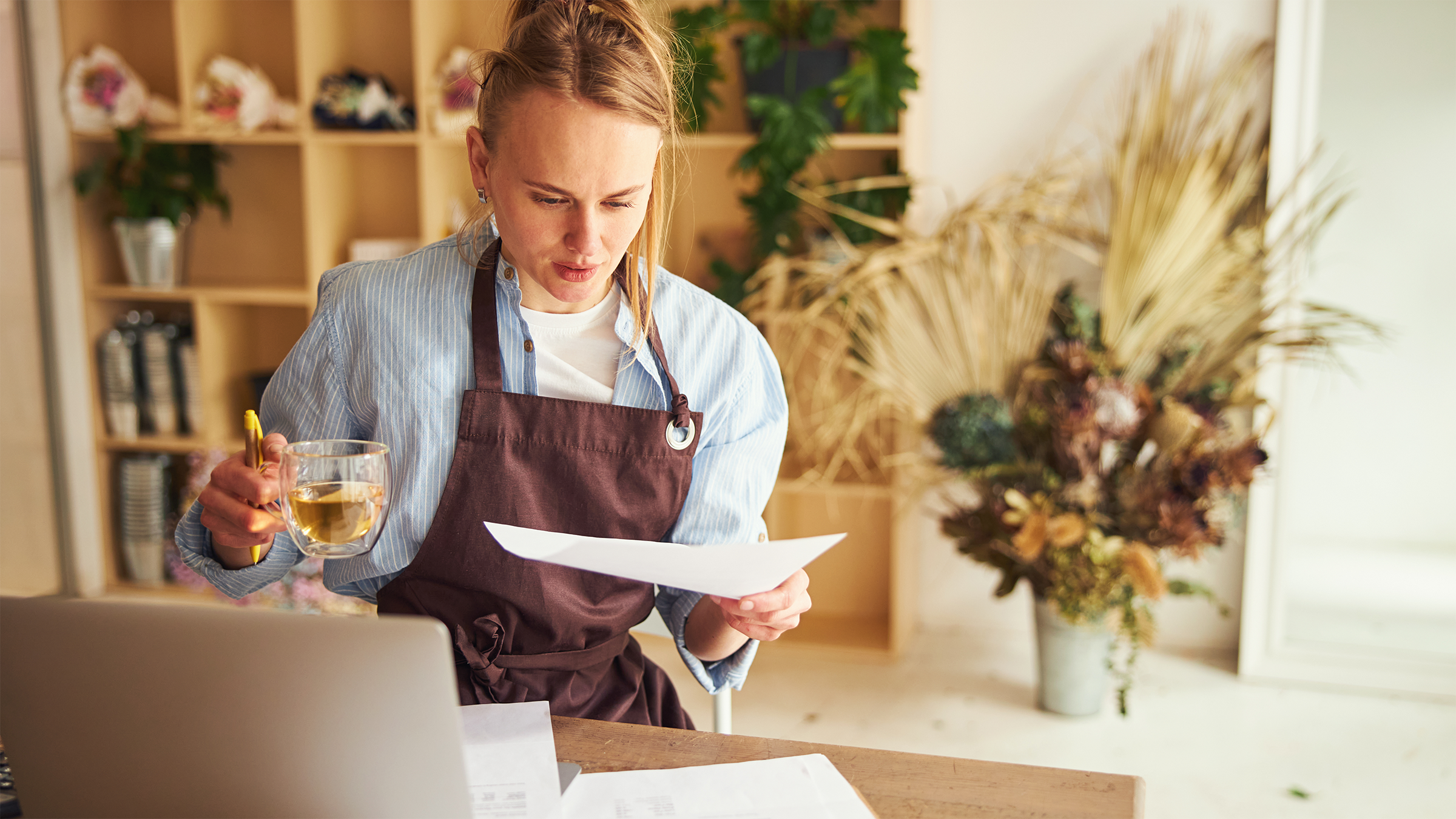 small business owner working at a laptop, reading about Arkansas franchise tax