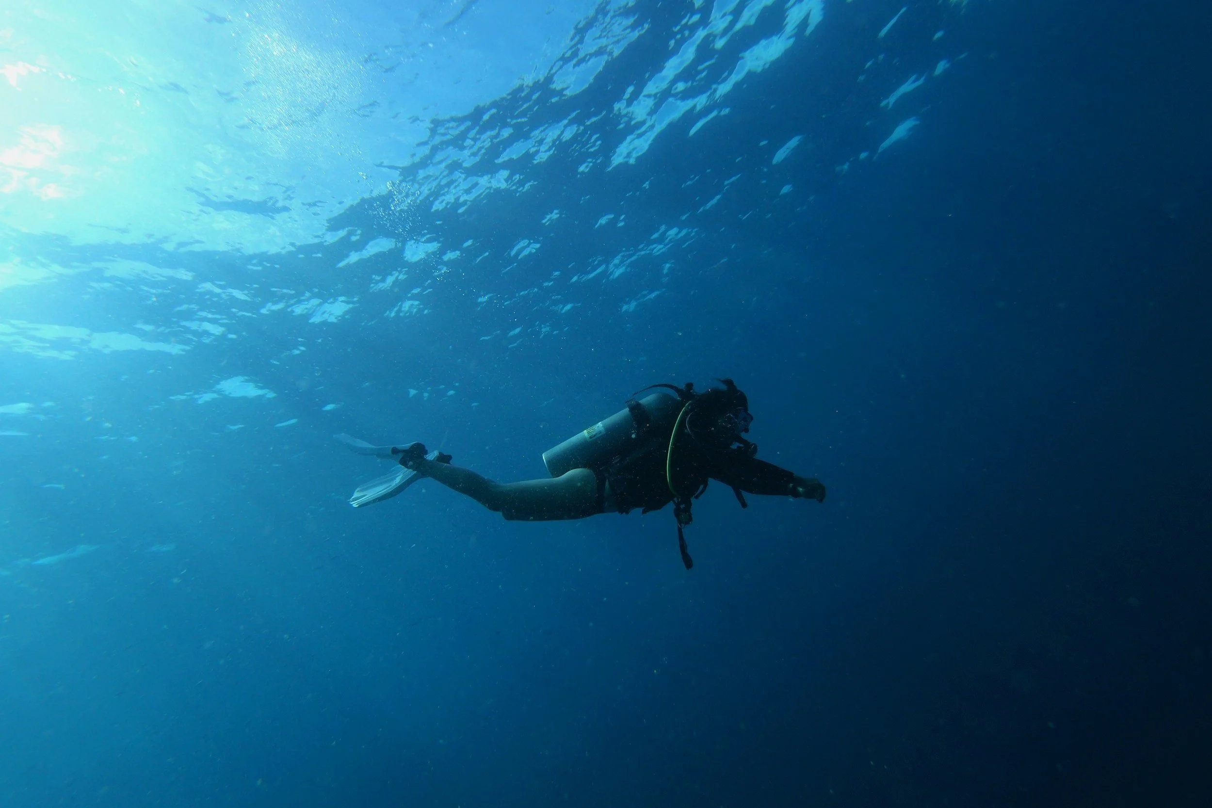 A scuba diver in the blue water having a good buoyancy position