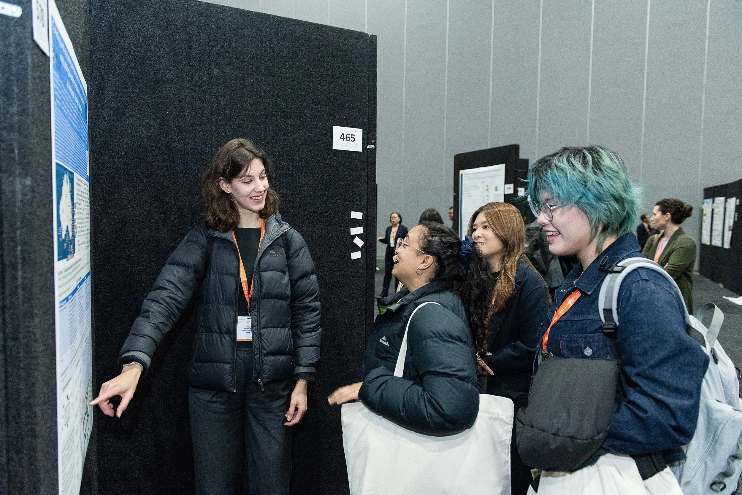 Delegates discussing a research poster at an MCEC conference