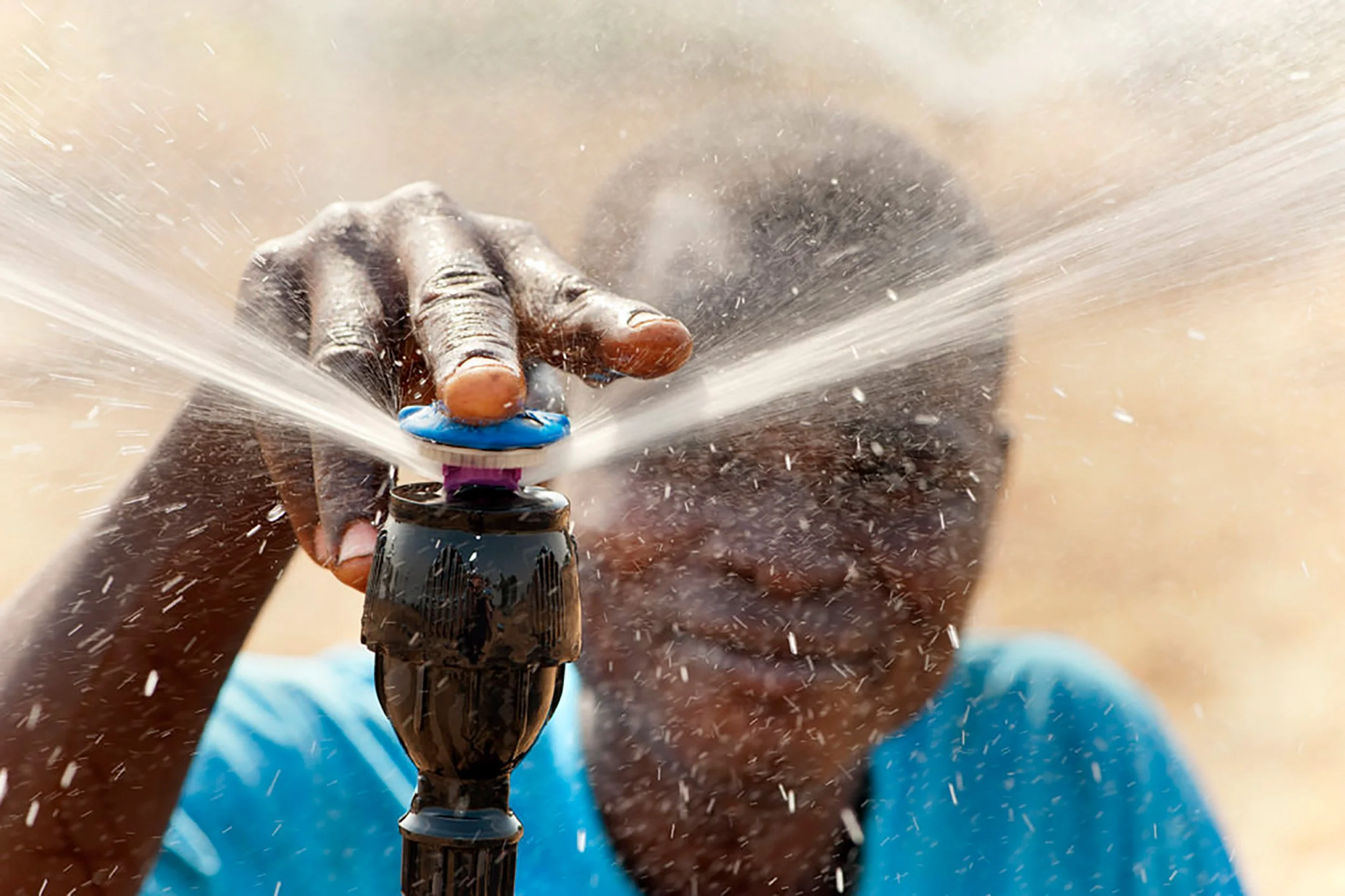 Farmer adjusting an agricultural irrigation sprinkler