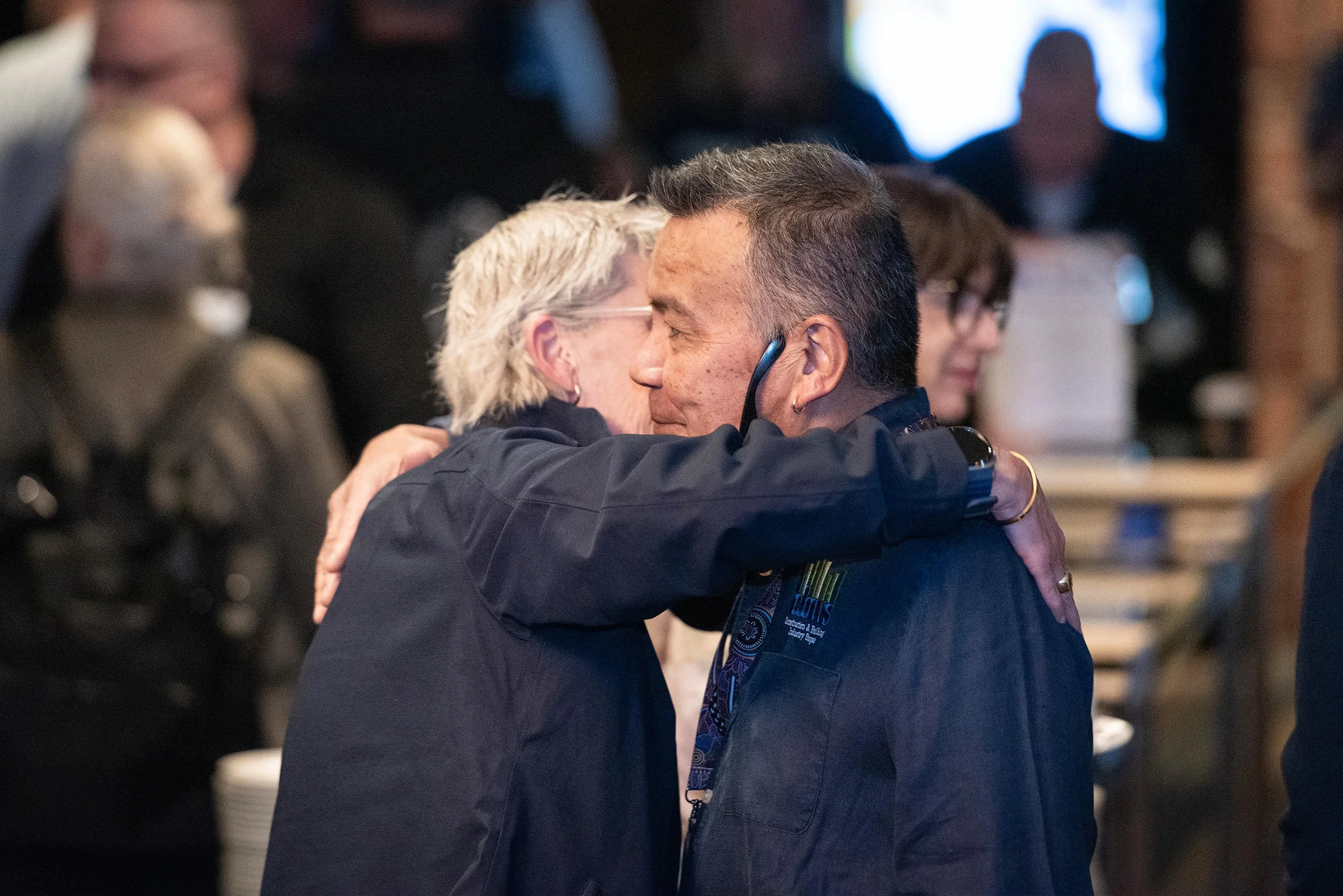 Two attendees embrace amid conversations during a break at Incolink’s Bluehats Conference.