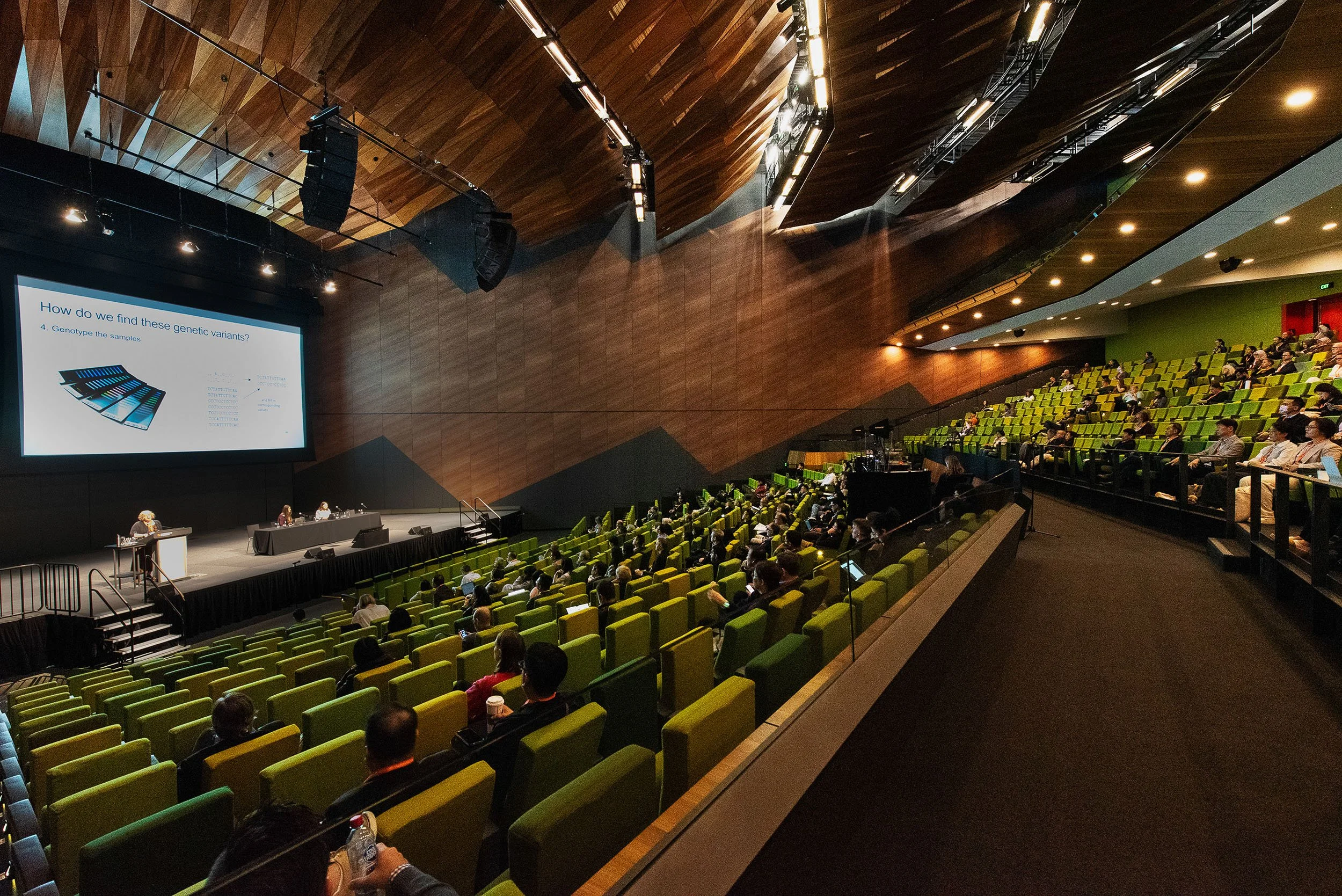 Delegates seated in an auditorium at Melbourne Convention and Exhibition Centre (MCEC) during a conference presentation.
