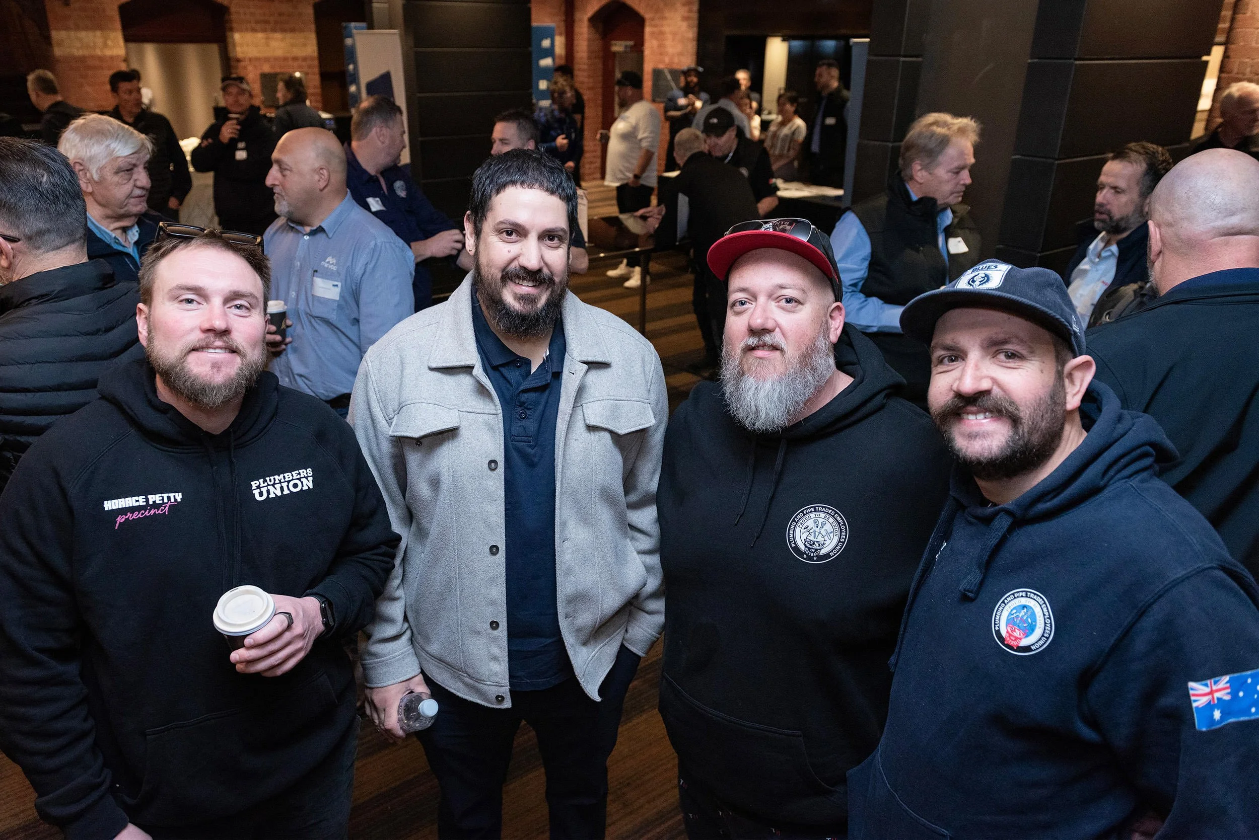 Four delegates smile for a group photograph during a networking break at Incolink’s Bluehats Conference.