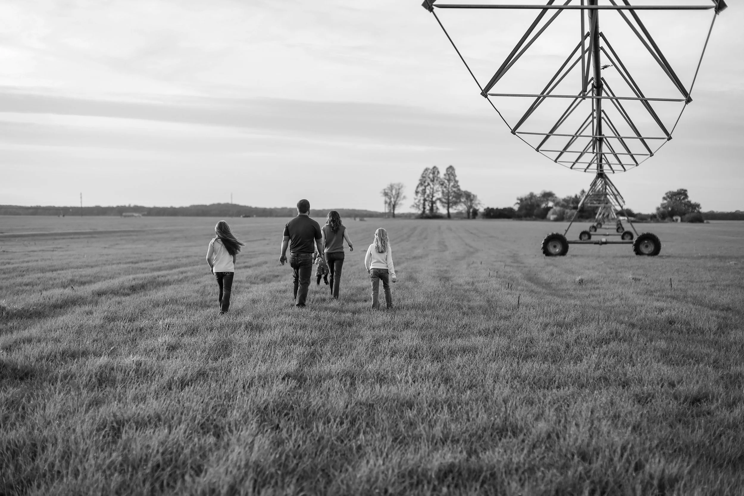 Family walking through their family farm during a portrait session in Kent County, MD, by dKin Photography.