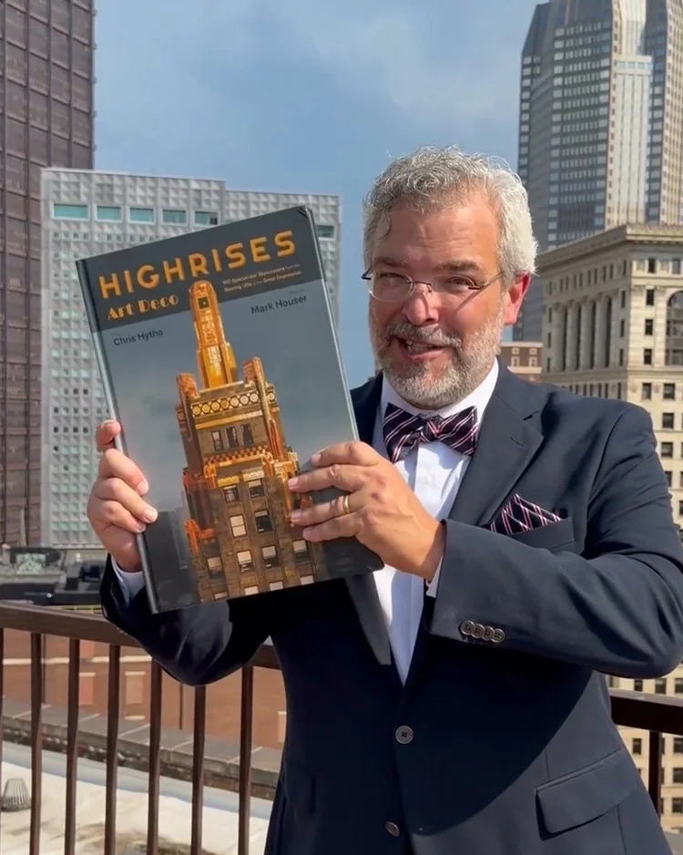 Co-author Mark Houser holding Highrises: Art Deco on a downtown rooftop