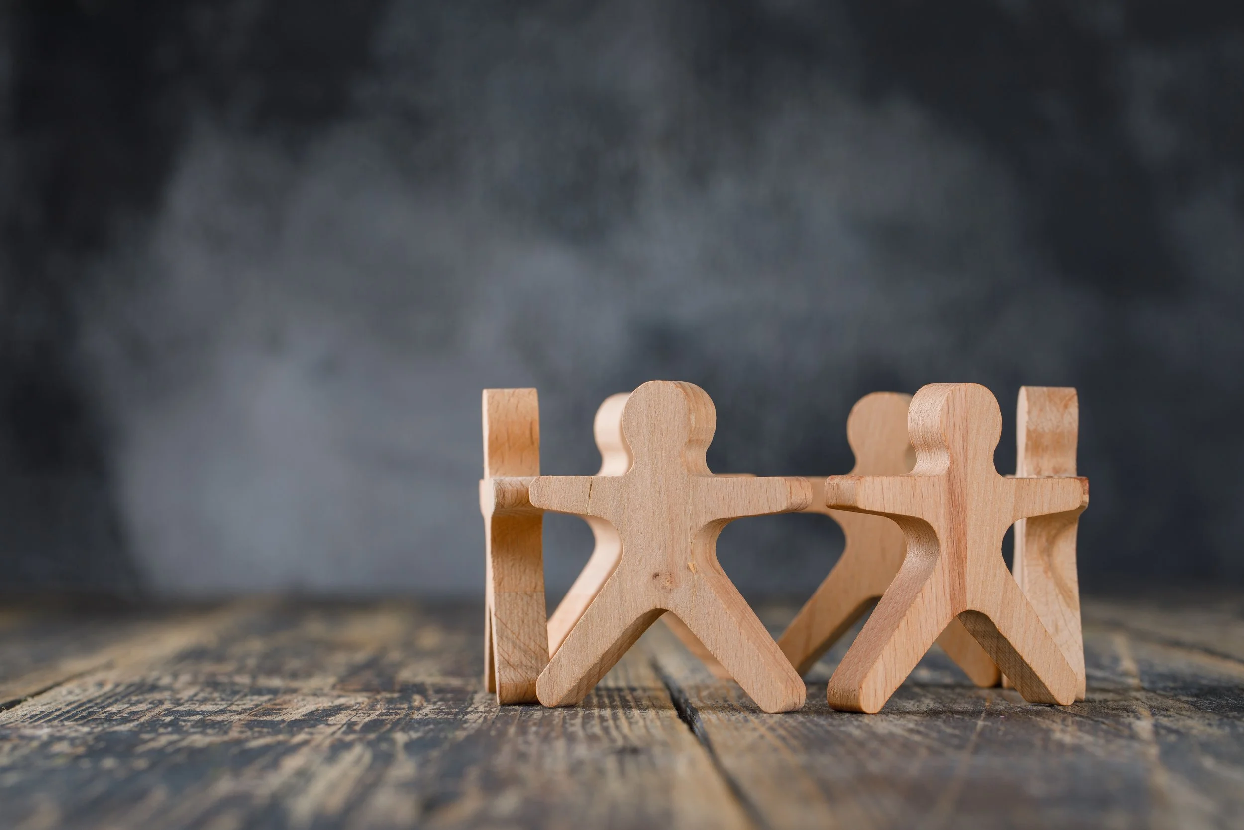 business-success-and-teamwork-concept-with-wooden-figures-of-people-side-view.jpg