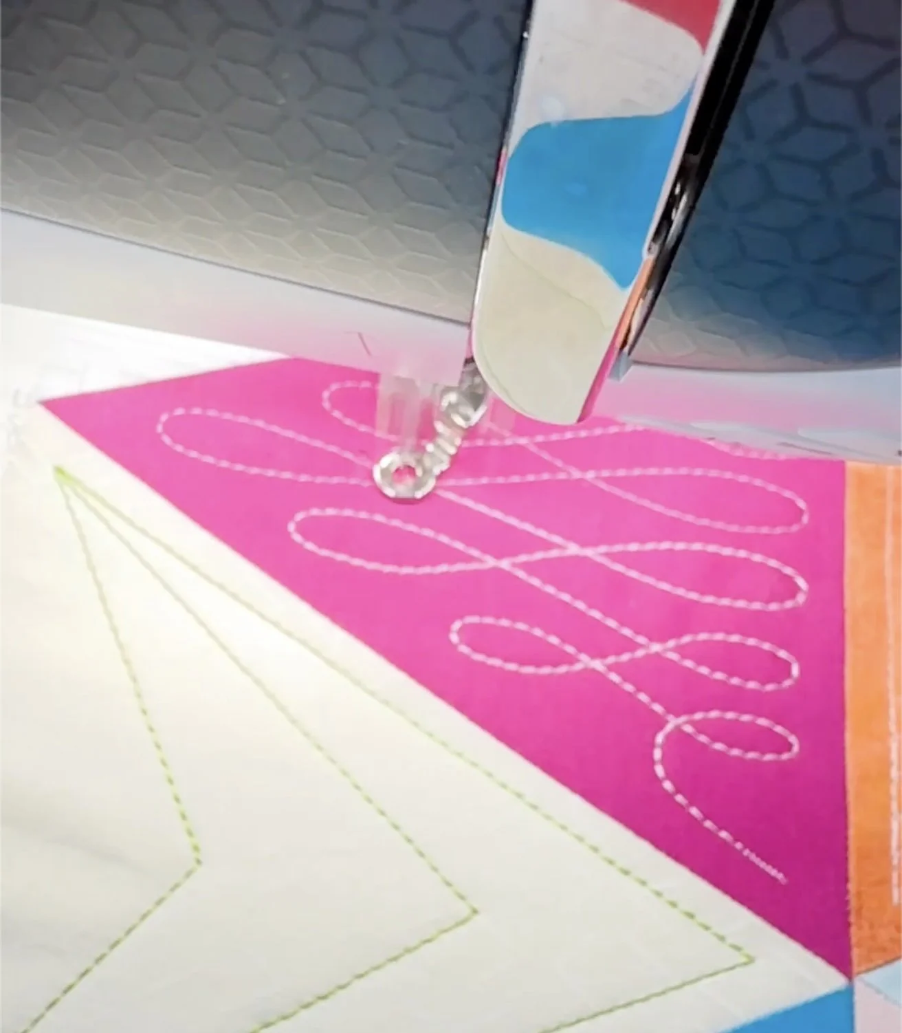 Detail view of precise quilting and decorative stitching on a colorful geometric pillow