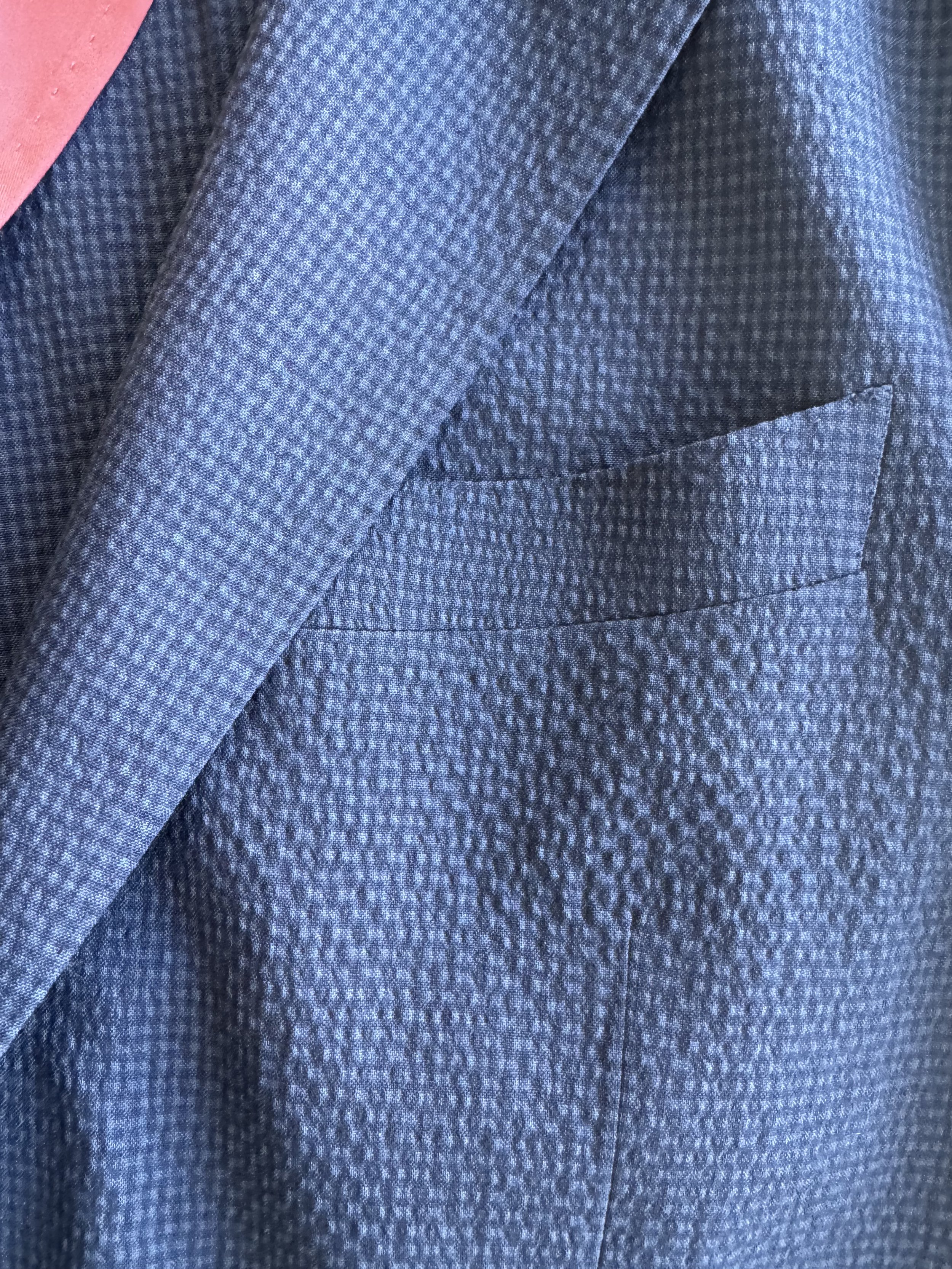 Close-up of Italian StylBiella seersucker fabric showing blue and navy check pattern and natural texture