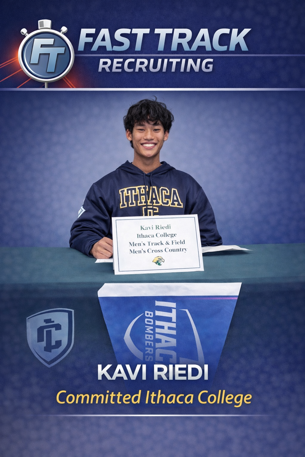 A young man in a navy blue Ithaca College hoodie sits at a table with an Ithaca College banner. He is smiling and holding a sign that says 'Kavi Riedi, Ithaca College, Men's Track & Field, Men's Cross Country' with the college logo.