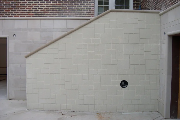 This concrete retaining wall stairway was sprayed with a thin cement overlay, using a limestone block stencil for patterning, to blend with the limestone block foundation of the home.