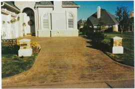 This driveway has a pattern that was stenciled on with a thin cement overlay before acid-staining. You can see how the beauty and contrast of the driveway seems to make the home stand out in "isolated elegance".