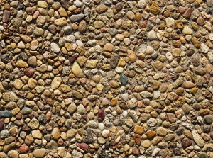 A closeup photo of properly sealed exposed aggregate concrete illustrating the color variation in stone, and "wet look" from the protective sealer.