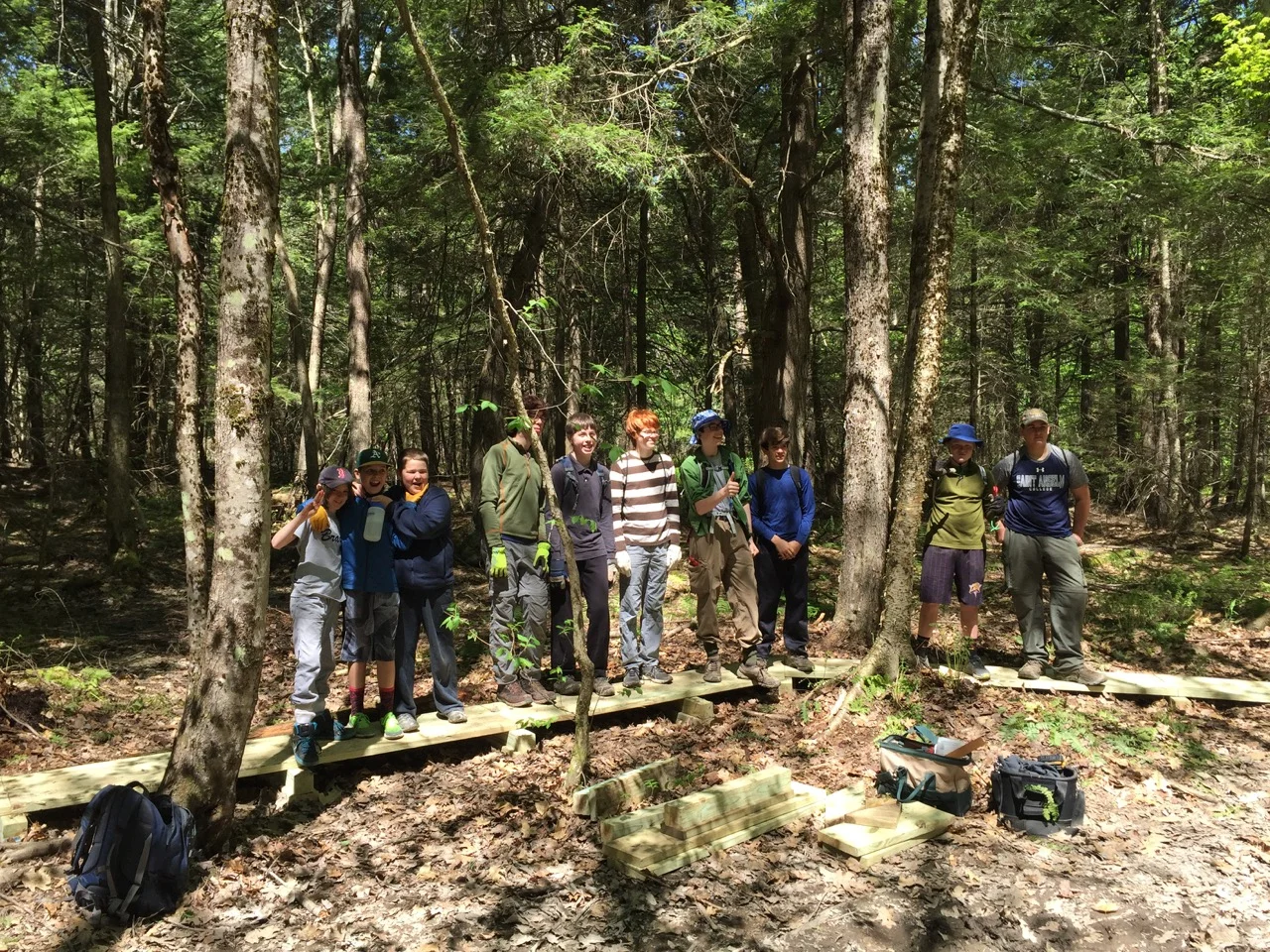 Members of Boy Scout Troop 93 stand on the bog bridging they helped build at Blackstrap Hill Preserve.