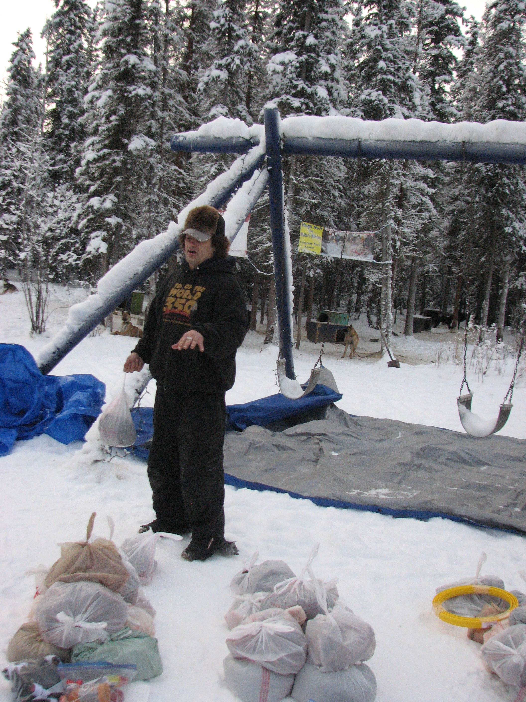 Hugh Neff explains the Iditarod checkpoint bags at his kennel.