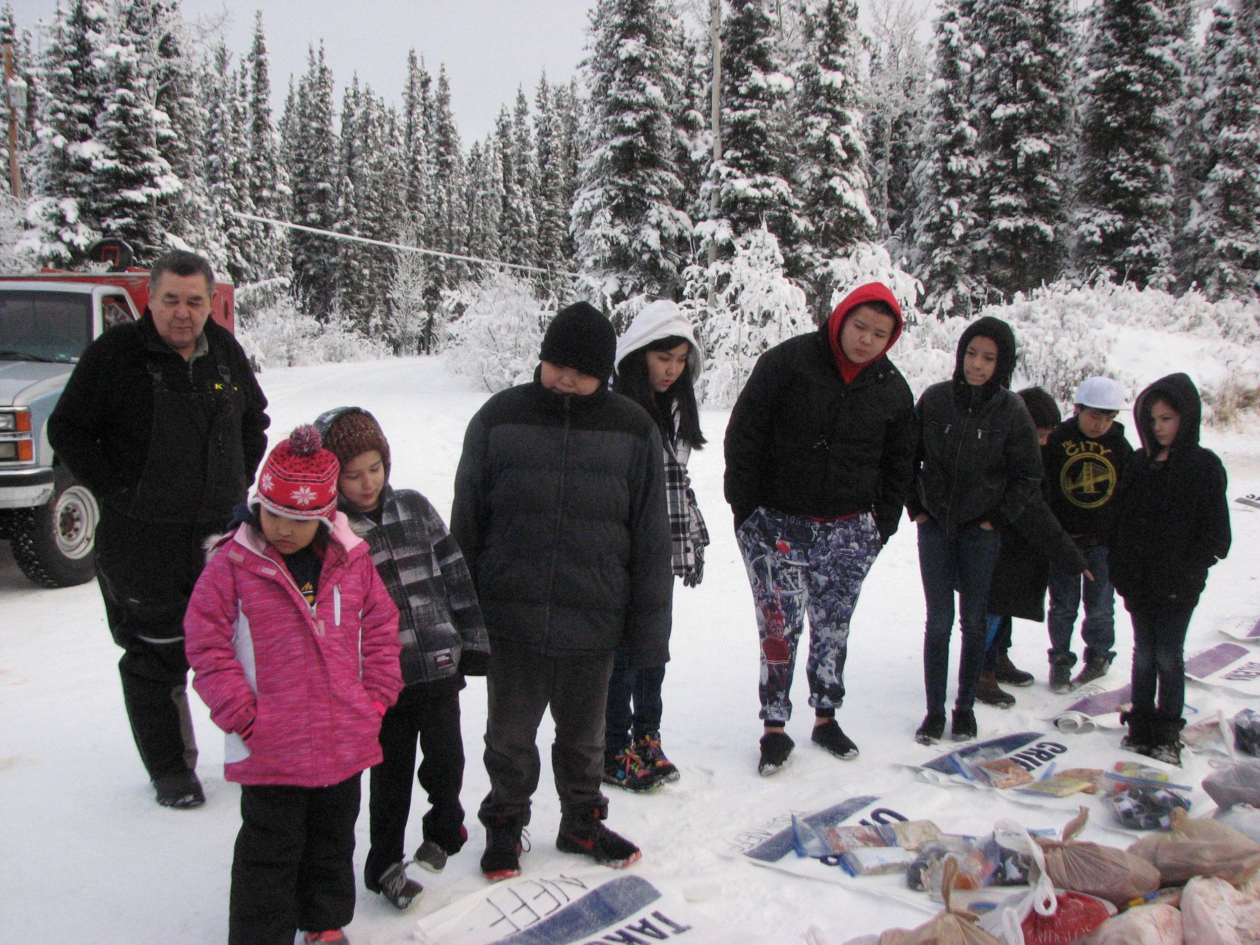 Tanacross students and Leonard Sanford learn more about the Iditarod checkpoint bags.