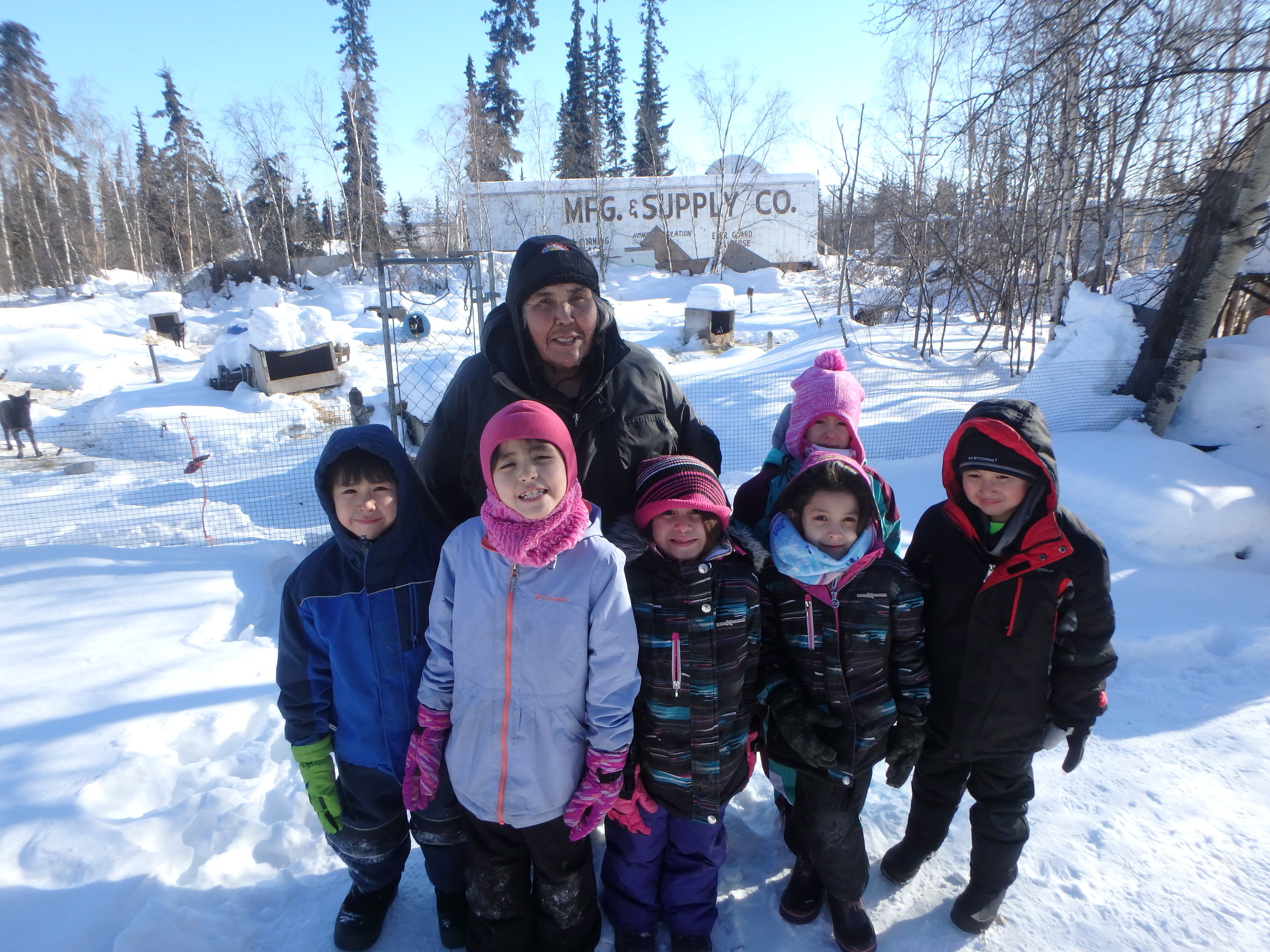 Minto School students with Musher Lloyd Charlie at his kennel.