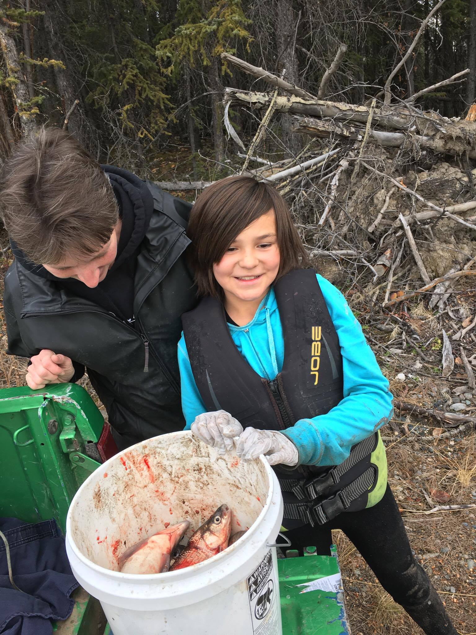 Student with caught fish in bucket.