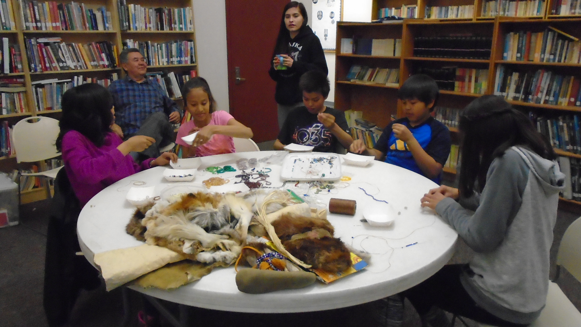 Students learn to bead with Amanda Attla.